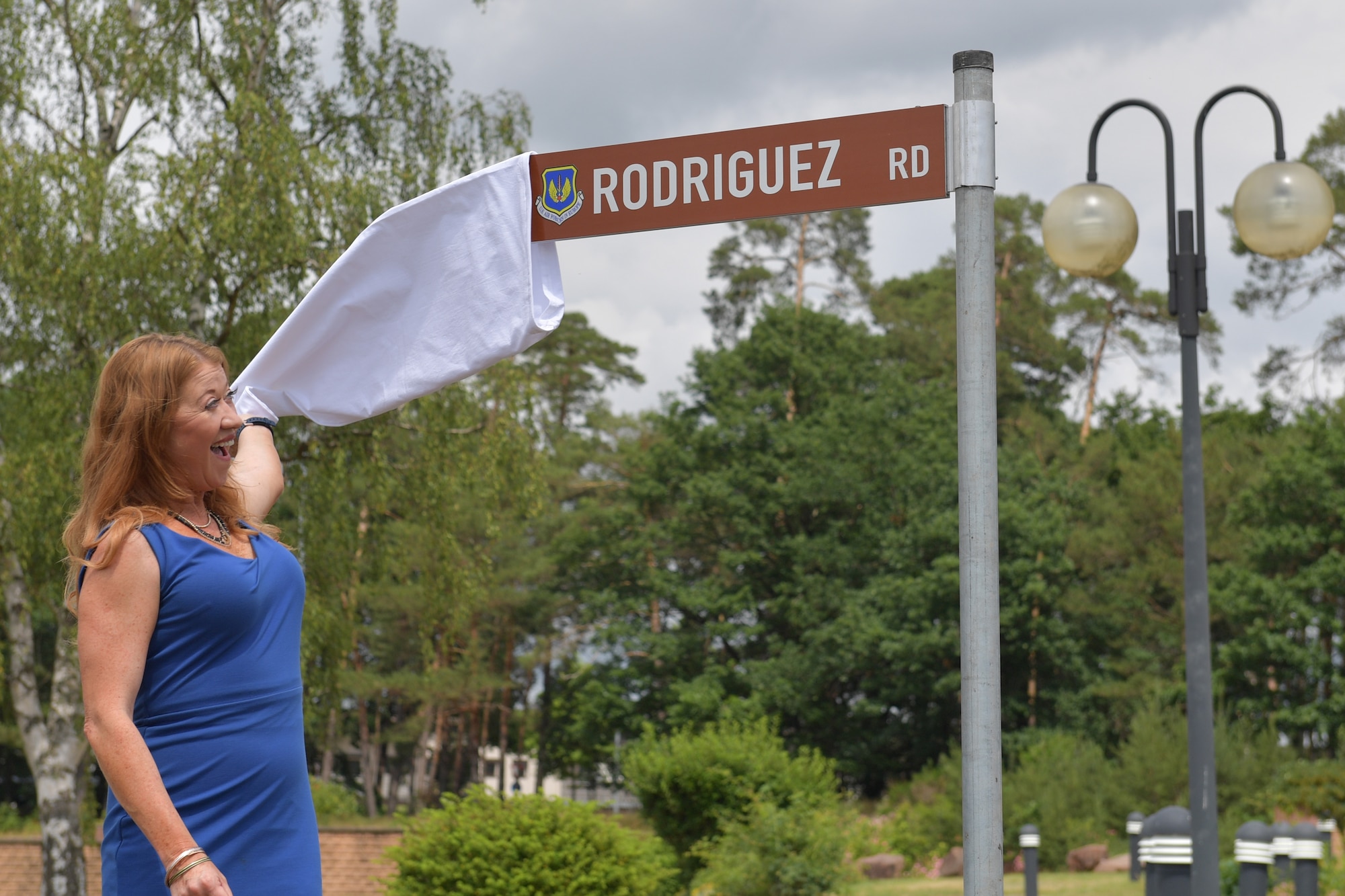 A person pulling a cloth cover off of a road sign.