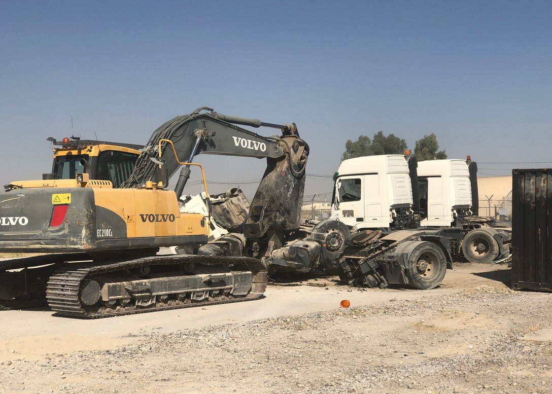 A heavy equipment operator uses shears to destroy one of the ten NATO bulk fuel carriers received at DLA Disposition Services' Kandahar site.