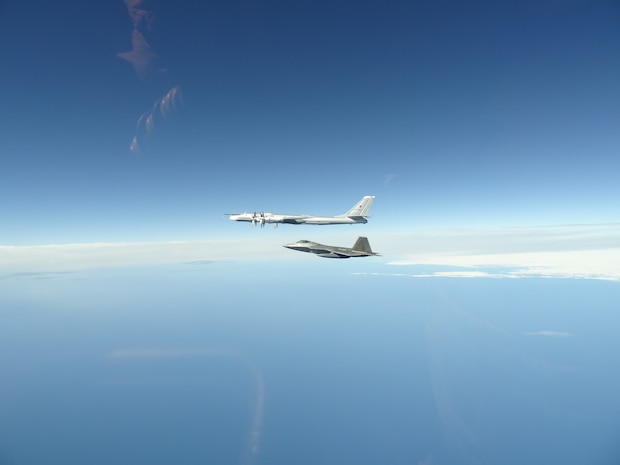 A North American Aerospace Defense Command F-22 Raptor flies next to a Russian Tu-95 bomber during an intercept in the Alaskan Air Defense Identification Zone June 16, 2020.