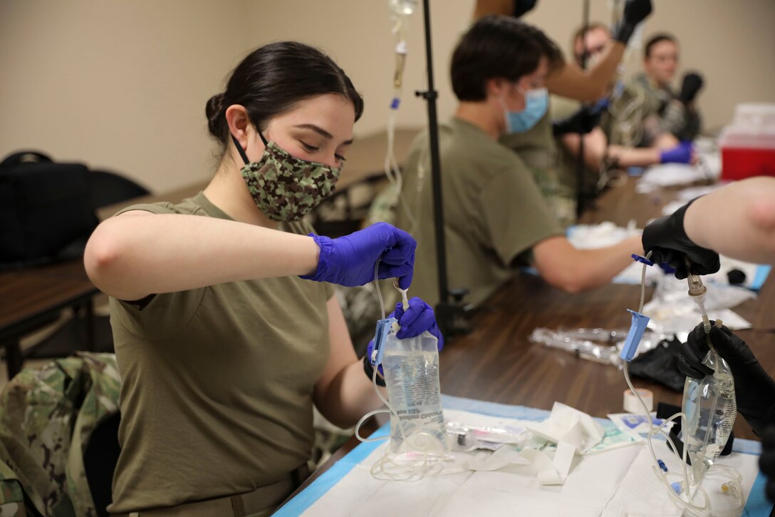 Soldiers practice using IV equipment.