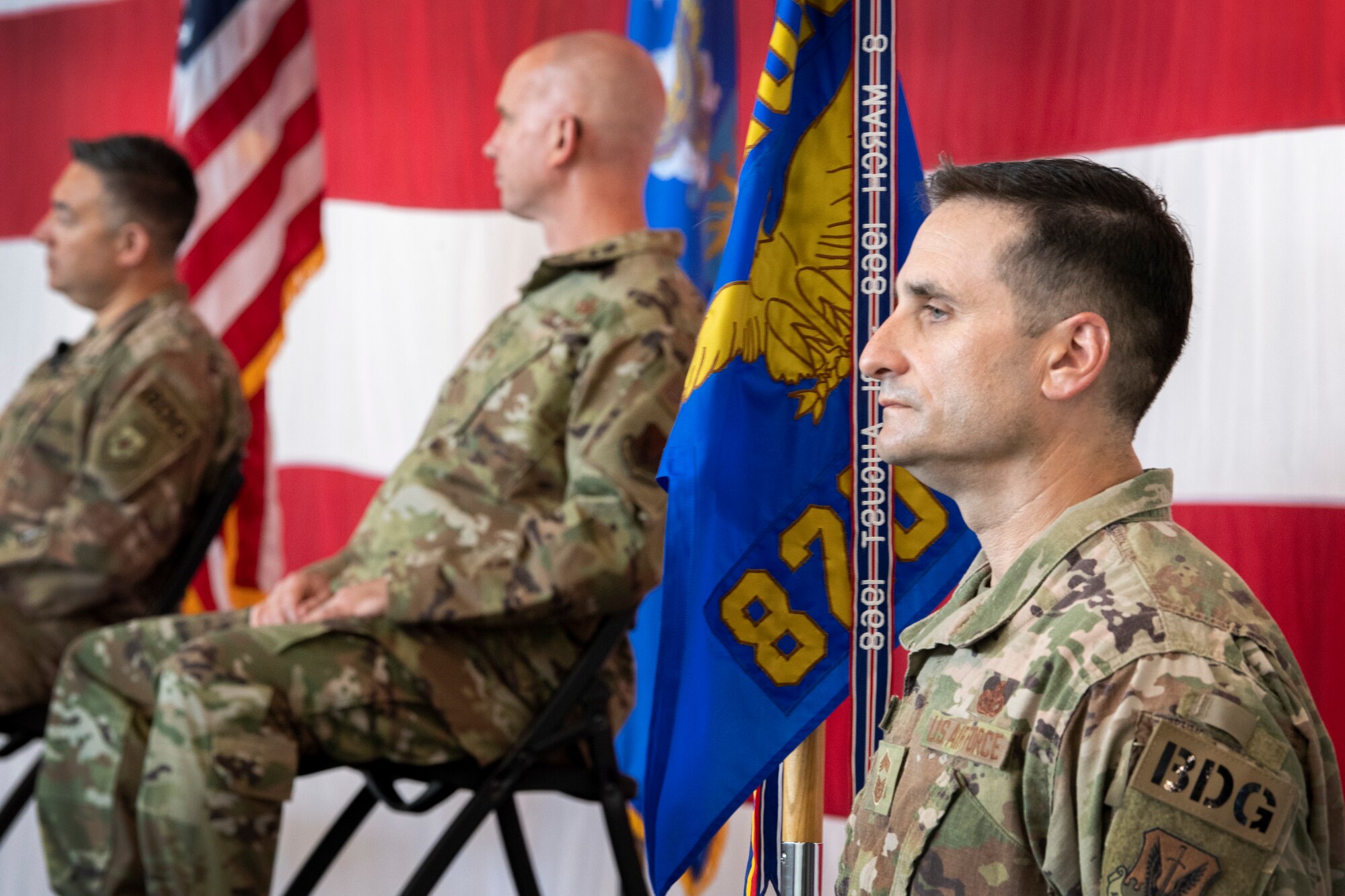 Group superintendent holds guidon during ceremony