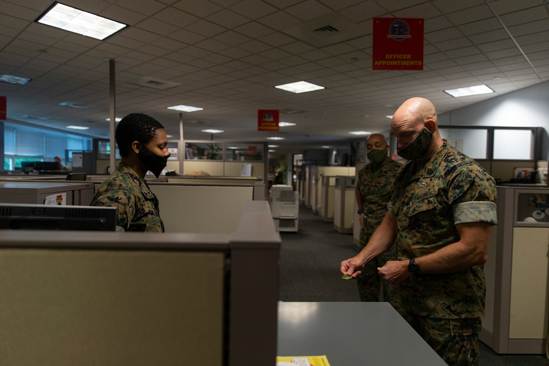 U.S. Marine Corps SgtMaj. Troy Black, 19th Sergeant Major of the Marine Corps, presents his coin to Lance Cpl. Alexus Lester, the administrative clerk for Officer Programs for the Marine Corps Recruiting Command (MCRC) at Marine Corps Base Quantico, Virginia, June 15, 2020. Black was visiting his previous duty station and took time to visit each Marine, sailor, and civilian and see how they were doing. (U.S. Marine Corps photo by Lance Cpl. Phuchung Nguyen)