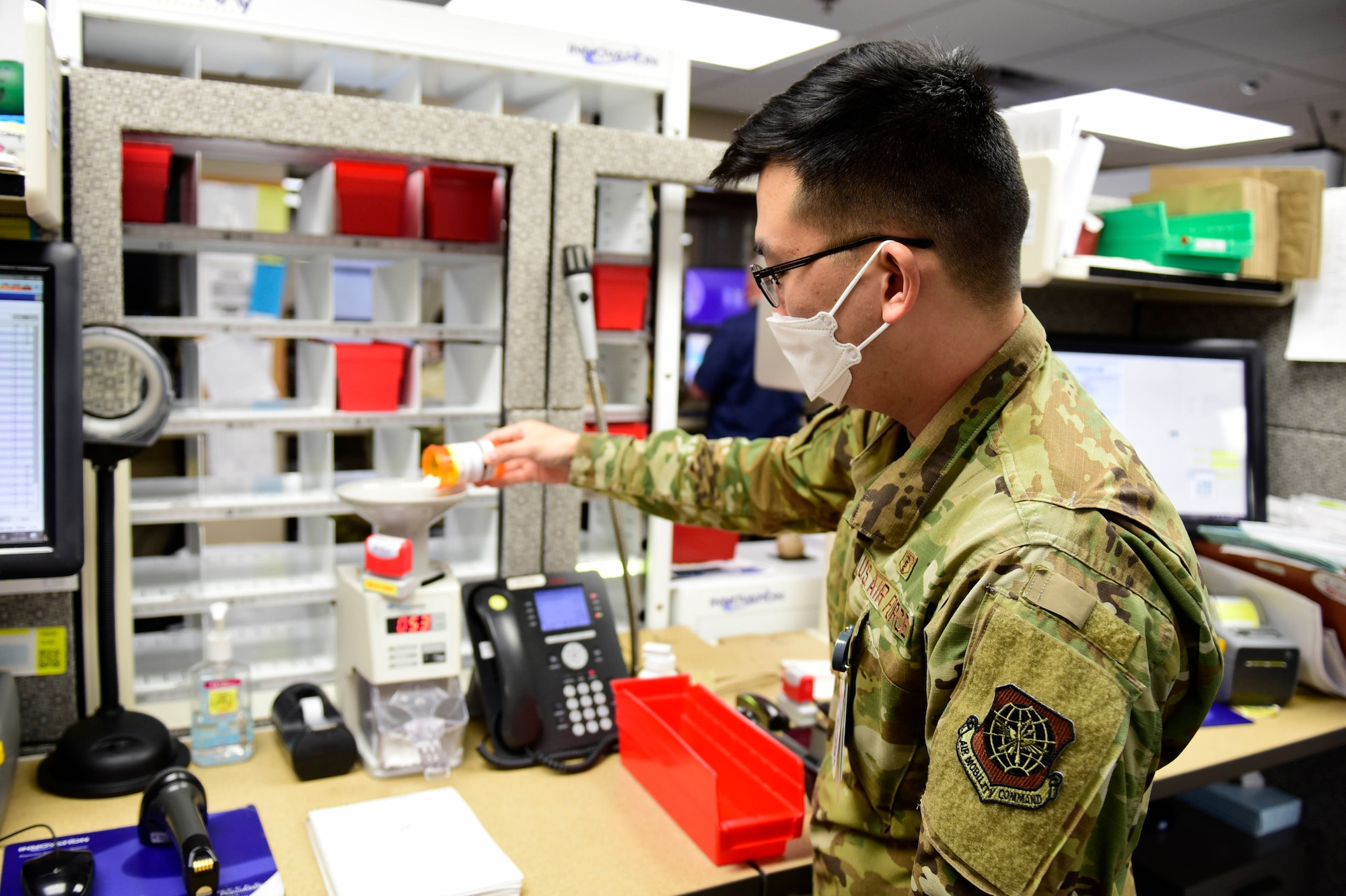 Capt. David Kim, 92nd Medical Support Squadron chief of pharmacy operations, pours medication into a medication counting machine, May 29, 2020, at Fairchild Air Force Base, Wash. Even after initial dispensing of medications, a new medication count is conducted to ensure accuracy across all stages of the pharmacy processes before giving patients their prescriptions. (U.S. Air Force photo by Staff Sgt. Nick J. Daniello)