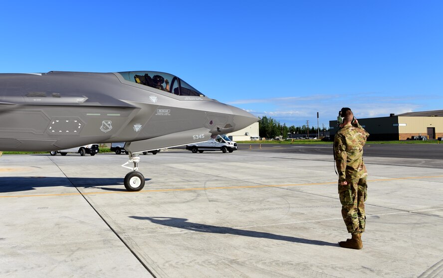 U.S. Air Force Lt. Col. Samuel Chipman, the 356th Fighter Squadron director of operations, returns a salute to Airman 1st Class Anthony Clark, a 356th Aircraft Maintenance Unit F-35A Lightning II crew chief, as he taxis to the runway at Eielson Air Force Base, Alaska, June 17, 2020.