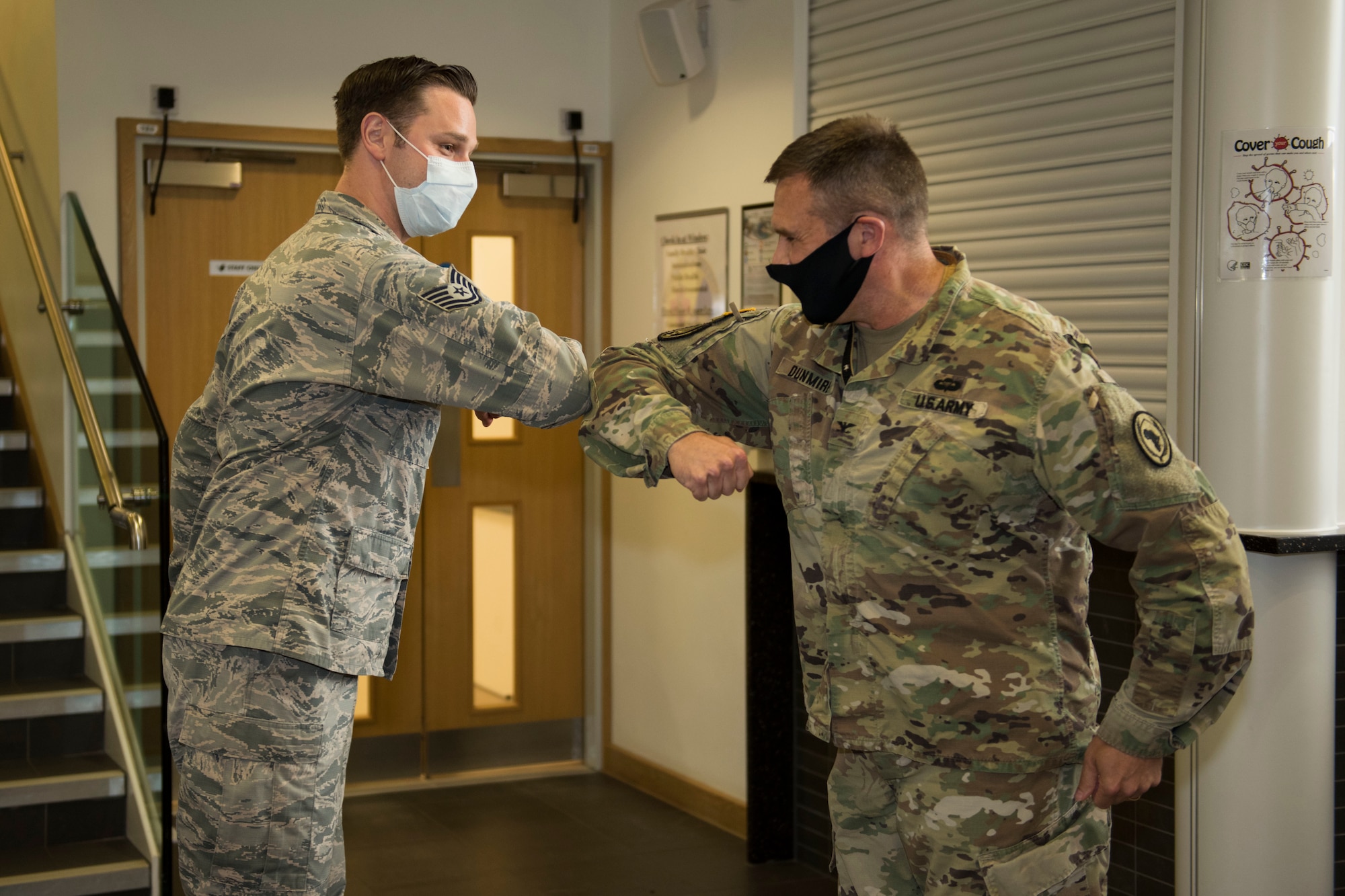 U.S. Army Col. Brian Dunmire, U.S. Africa Command Directorate for Intelligence at RAF Molesworth multi-service commander, and U.S. Air Force Chief Master Sgt. Dan Spencer, USAFRICOM J2-M senior enlisted leader, present coins of excellence to 423rd Medical Squadron personnel at RAF Alconbury, England, June 11, 2020. Dunmire and Spencer launched “AFRICOM Aces,” a new initiative to recognize mission partner personnel and the off-base community, who go above and beyond in performance of their job. (U.S. Air Force photo by Airman 1st Class Jennifer Zima)