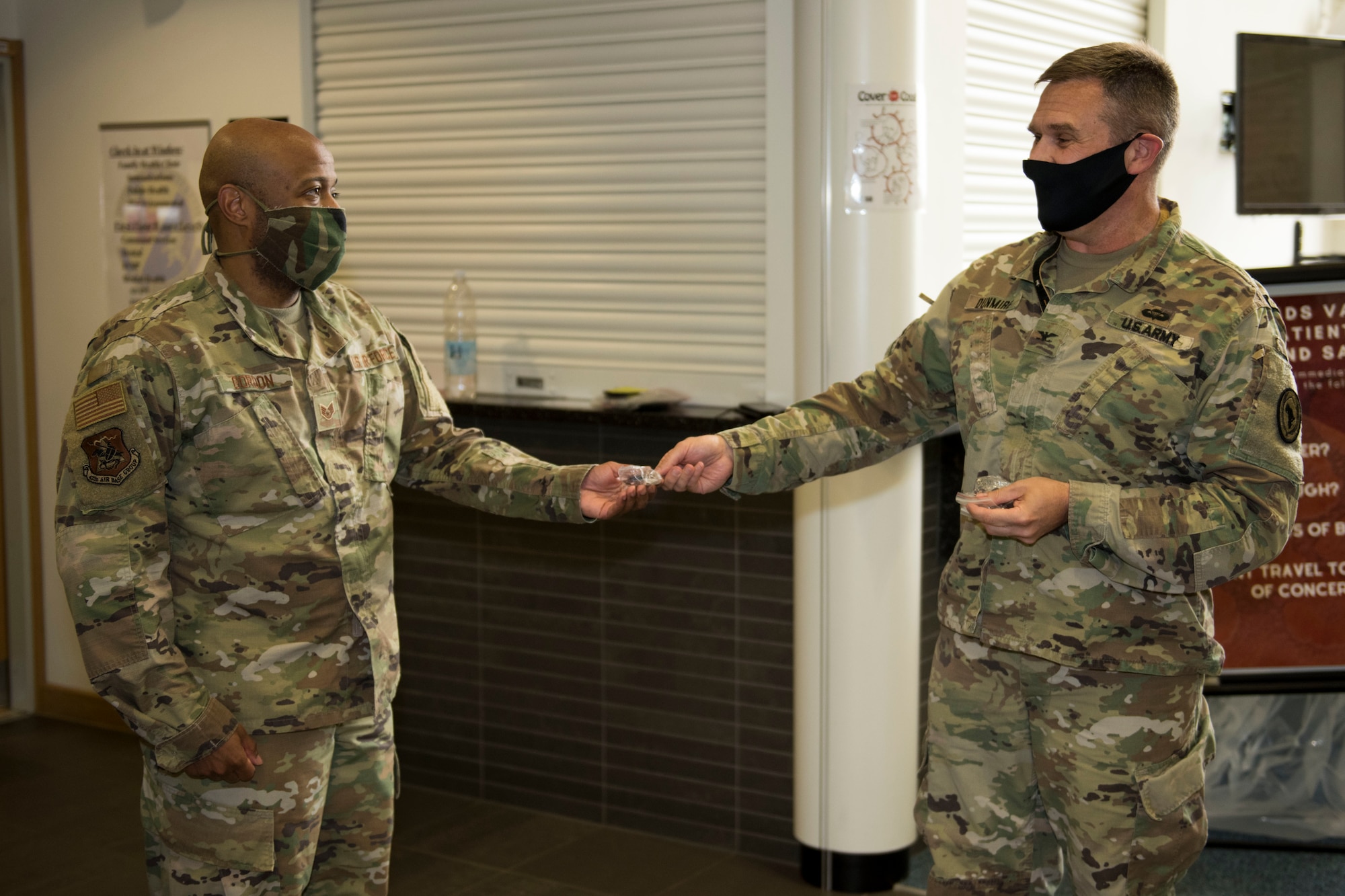 U.S. Army Col. Brian Dunmire, U.S. Africa Command Directorate for Intelligence at RAF Molesworth multi-service commander, and U.S. Air Force Chief Master Sgt. Dan Spencer, AFRICOM senior enlisted leader, present coins of excellence to 423rd Medical Squadron personnel at RAF Alconbury, England, June 11, 2020. Dunmire and Spencer launched “AFRICOM Aces,” a new initiative to recognize mission partner personnel and the off-base community, who go above and beyond in performance of their job. (U.S. Air Force photo by Airman 1st Class Jennifer Zima)