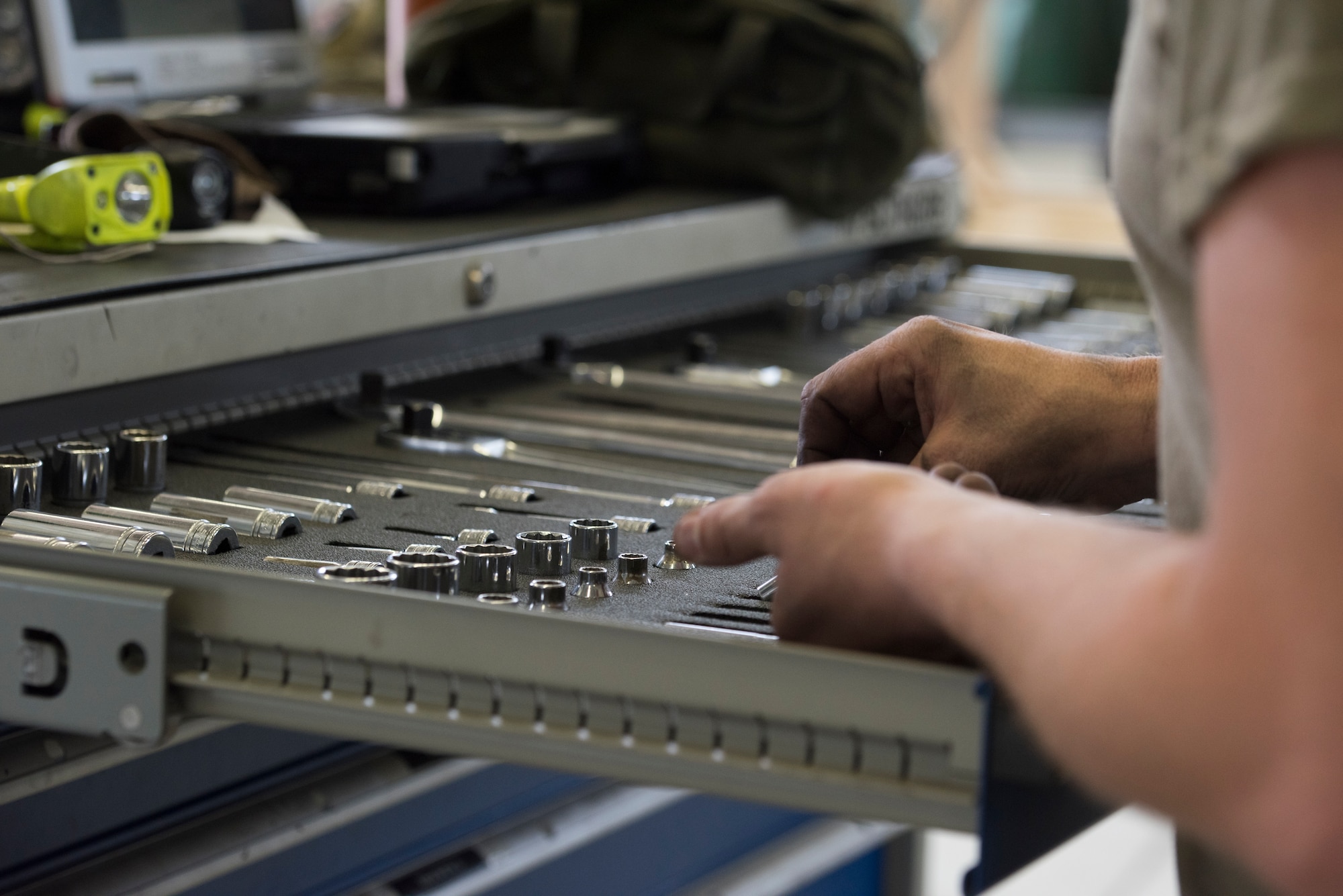 A photo of an Airman searching for tools.