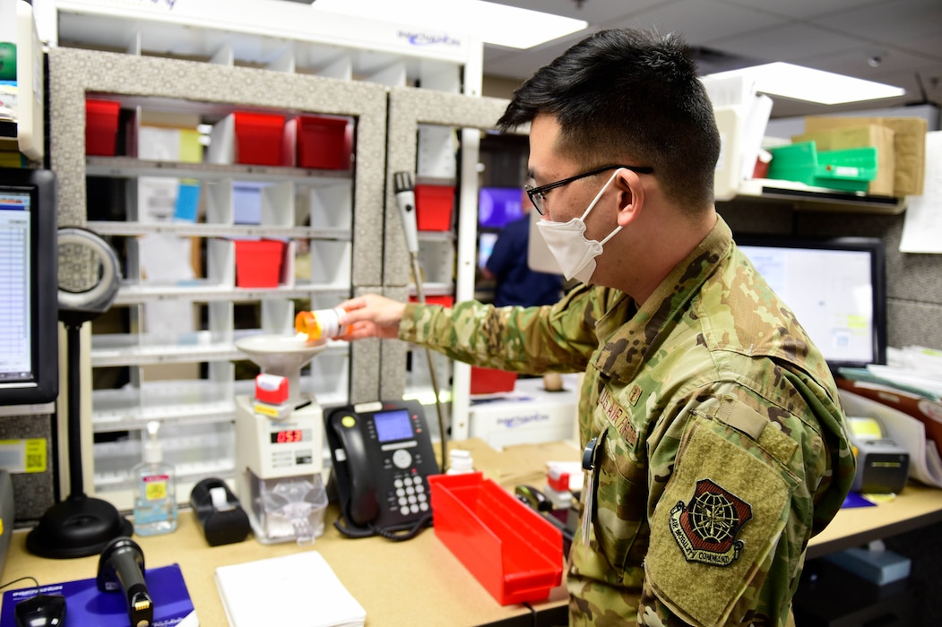 Image of an Airman pouring pills into a machine