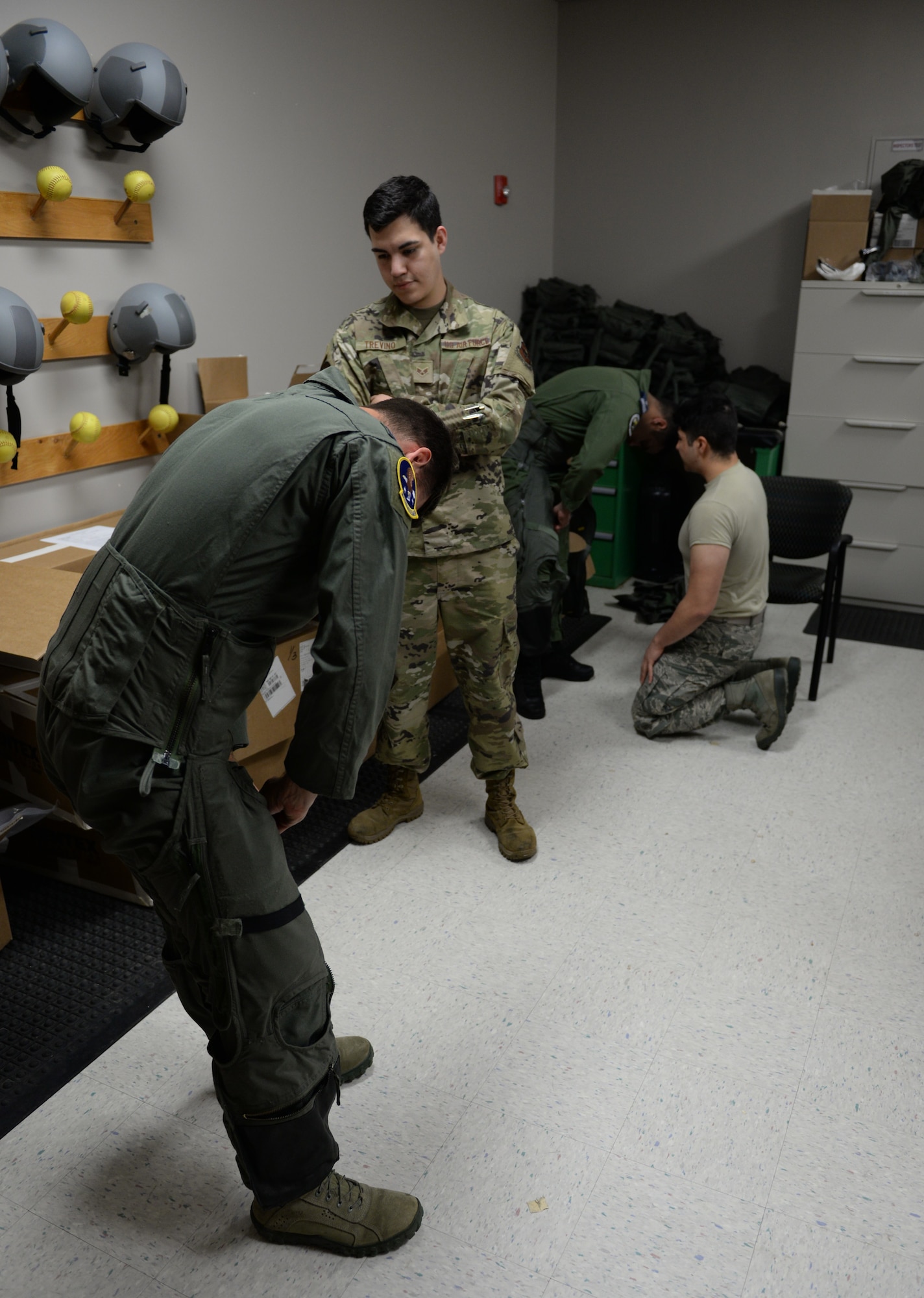 Two 37th Flying Training Squadron student pilots try on G-suits, while two 37th FTS Aircrew Flight Equipment specialists make sure the suit fits correctly on June 10, 2020, at Columbus Air Force Base Miss. A G-suit helps pilots withstand the acceleration forces put on their bodies while maneuvering aircraft. (U.S. Air Force photo by Airman 1st Class Davis Donaldson)