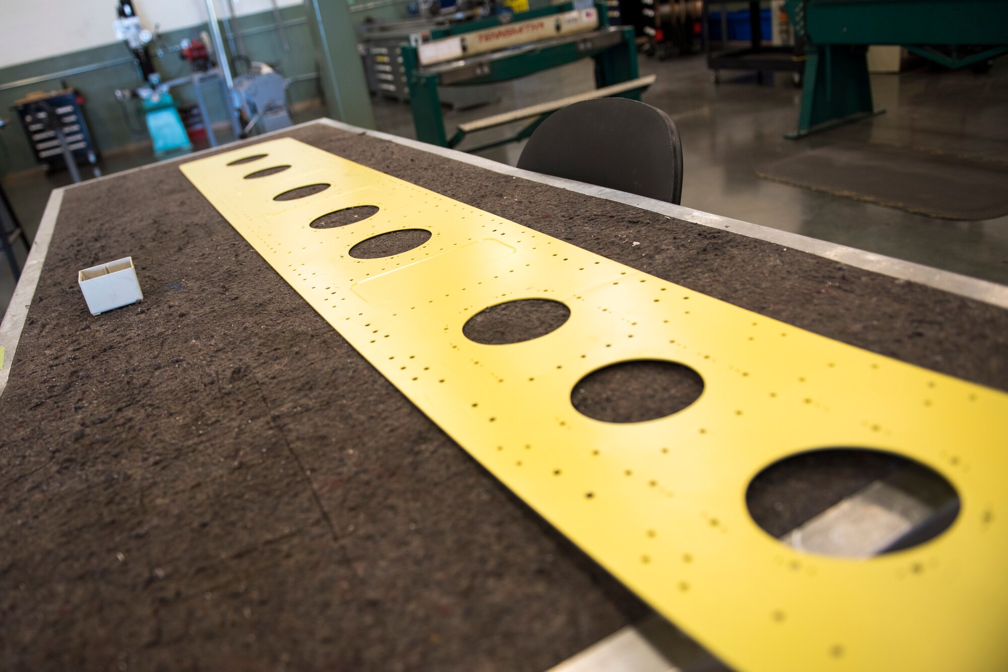An eight-foot long metal panel from a C-17 cargo ramp lays on a table in the 167th Airlift Wing’s sheet metal shop after being sandblasted to remove corrosion and primed, May 27, 2020.
