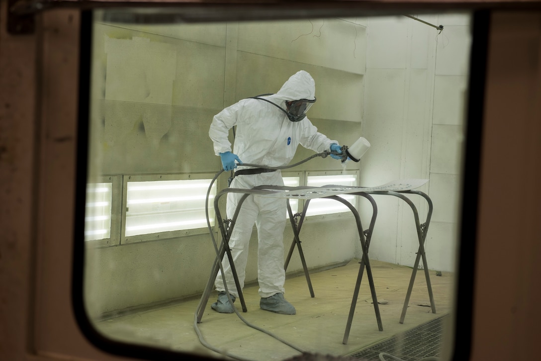 Staff Sgt. Doug Miller, aircraft maintainer for the 167th Maintenance Group, sprays a coat of paint on a metal panel, part of a C-17 Globemaster III aircraft cargo ramp canted bulkhead which had corroded over time due to sealed drainage holes, May27, 2020,at the 167th Airlift Wing, Martinsburg, W.Va