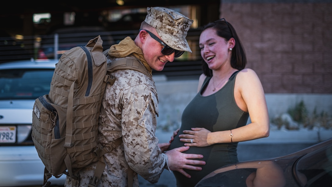 U.S. Marine Corps Lance Cpl. Collin T. Smart with 2nd Battalion, 7th Marine Regiment, 1st Marine Division, feels his pregnant wife's stomach after returning from a deployment, at Marine Corps Air Ground Combat Center, Twentynine Palms, Calif., May 15, 2020. The Marines returned from an eight-month deployment with the Special Purpose Marine Air Ground Task Force-Crisis Response-Central Command. (U.S. Marine Corps Photo by Lance Cpl. Shane T. Beaubien)