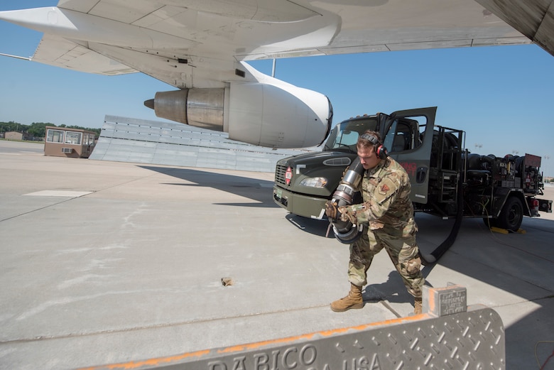 An Airmen pulls a hose from an R-12 refueling truck to the Type III Underground Fuel System.