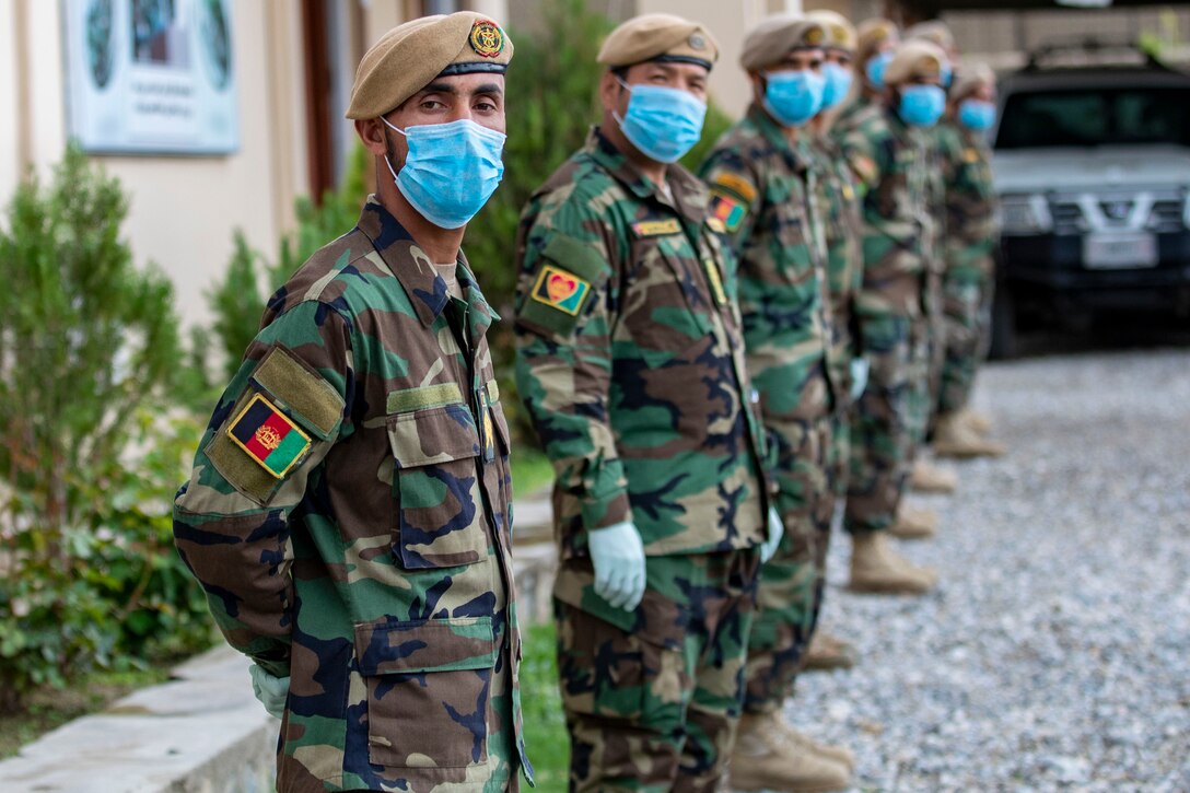 Masked Afghan soldiers stand in formation.