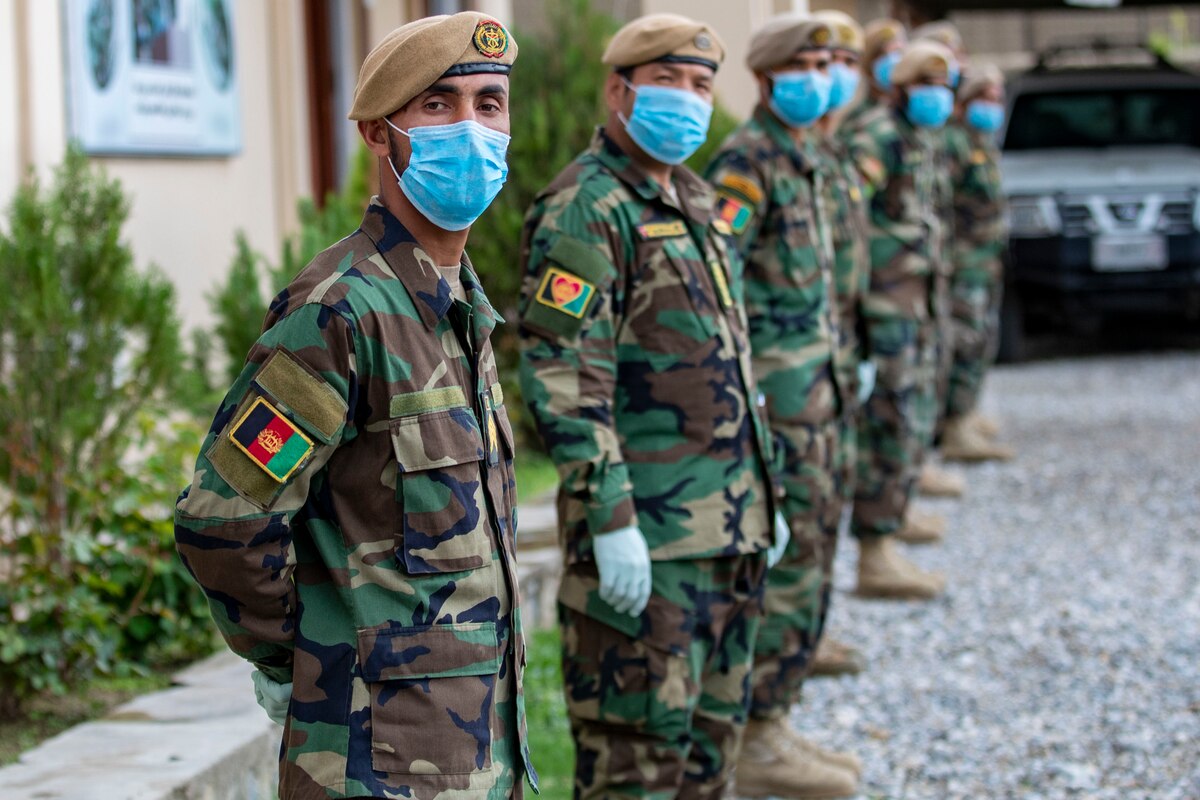Masked Afghan soldiers stand in formation.