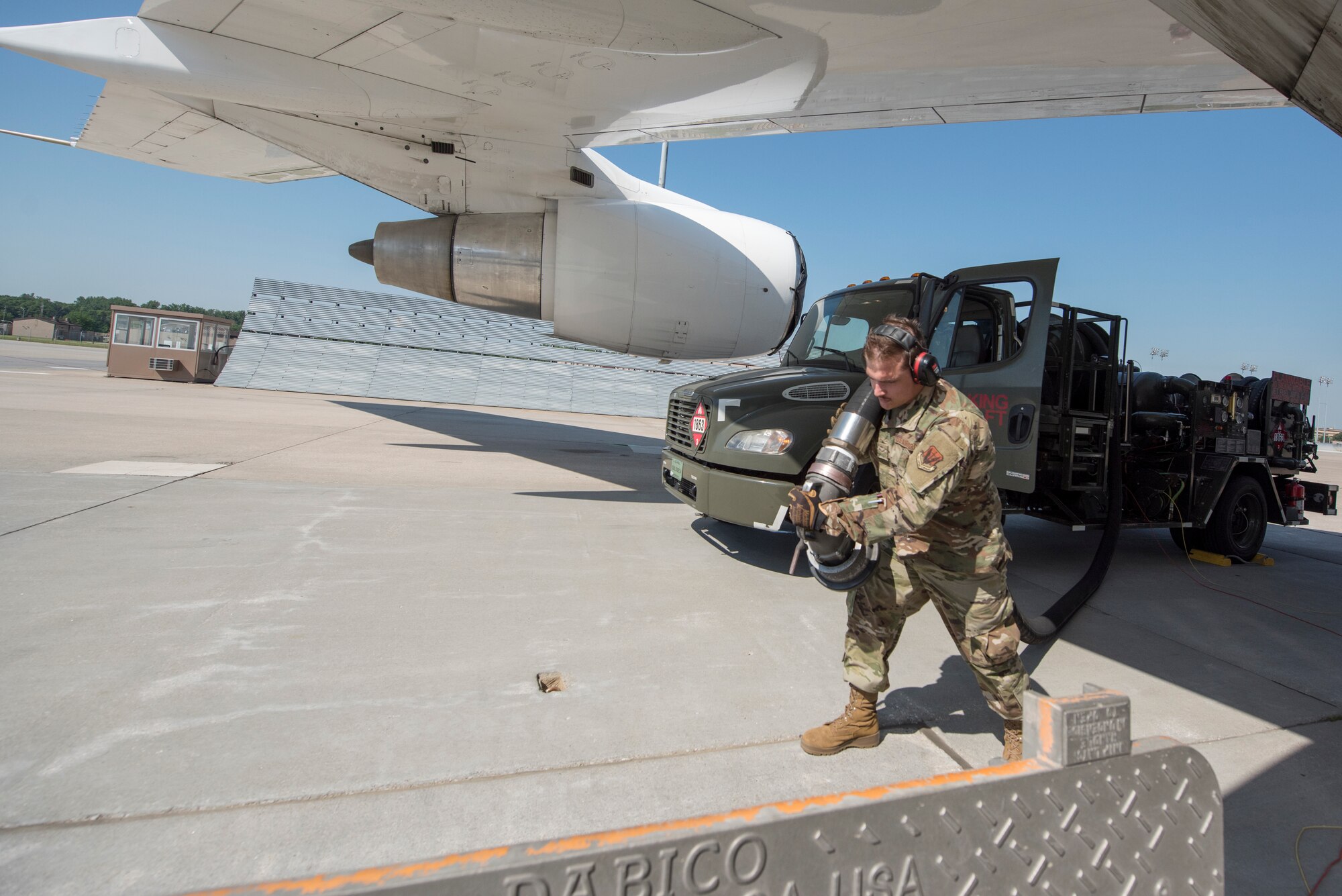 An Airmen pulls a hose from an R-12 refueling truck to the Type III Underground Fuel System.
