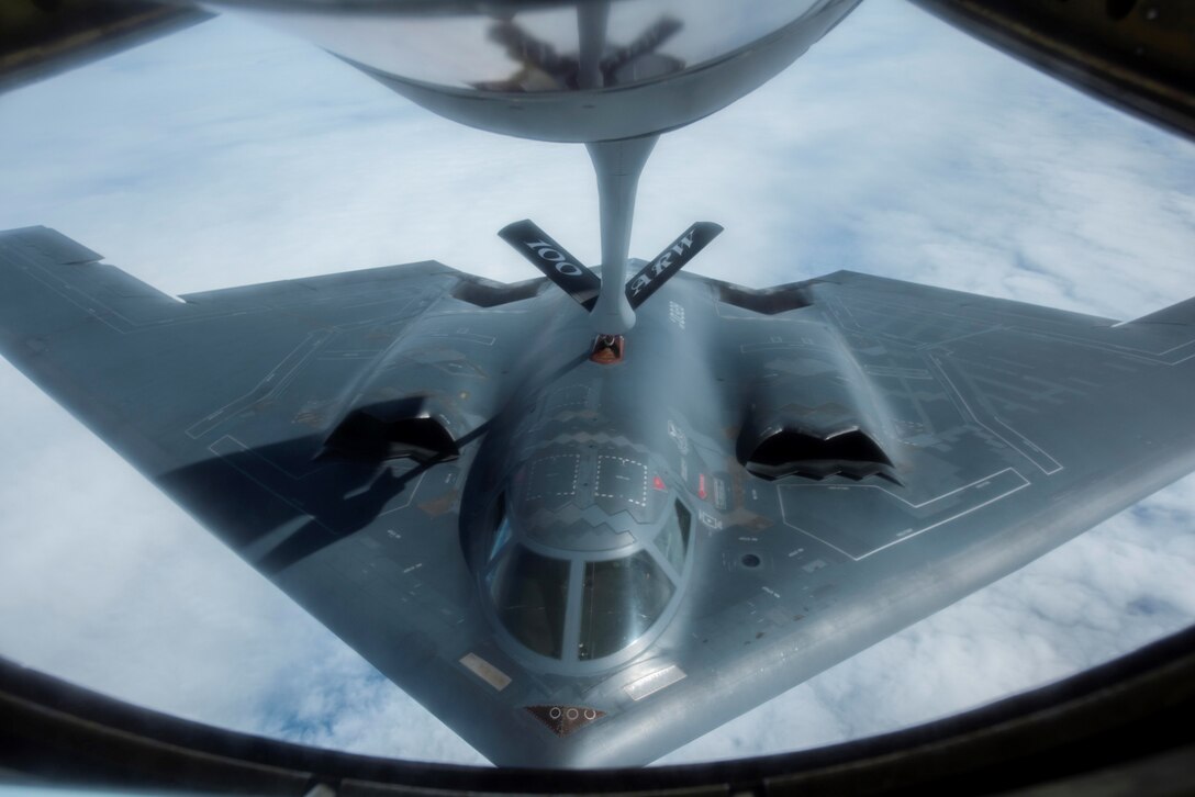 An aircraft refuels mid-air with assistance from another aircraft.