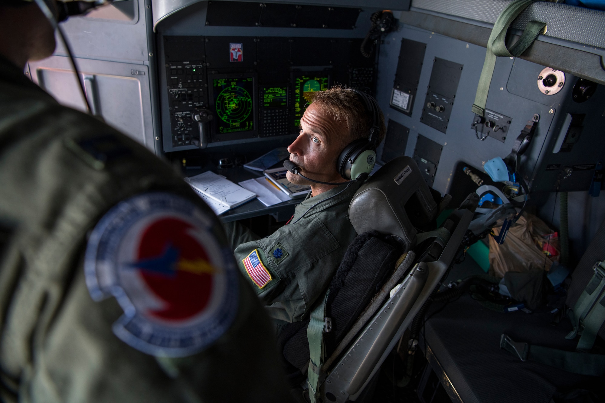 Lt. Col. Phillip Dobson, 53rd Weather Reconnaissance Squadron navigator, explains the duties of a navigator to Capt. Garrett Black, 53rd WRS aerial reconnaissance weather officer during a flight, June 17 over Caribbean. The Hurricane Hunters deployed to St. Croix to fly training missions over the Caribbean in preparation for the 2020 hurricane season. (U.S. Air Force photo by Tech. Sgt. Christopher Carranza)