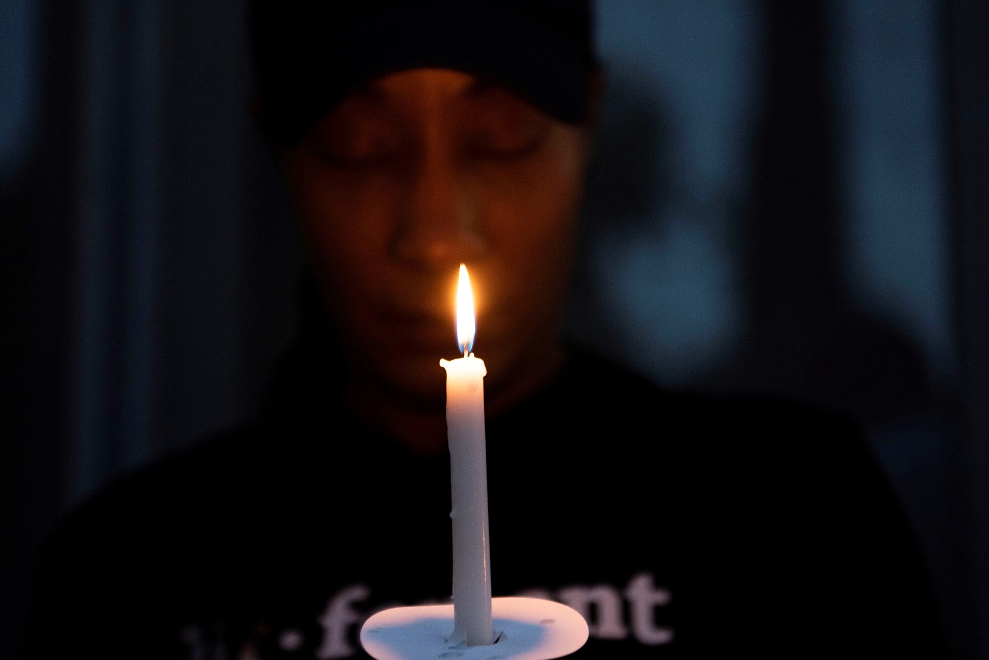 Photo of an Airman holding a candle