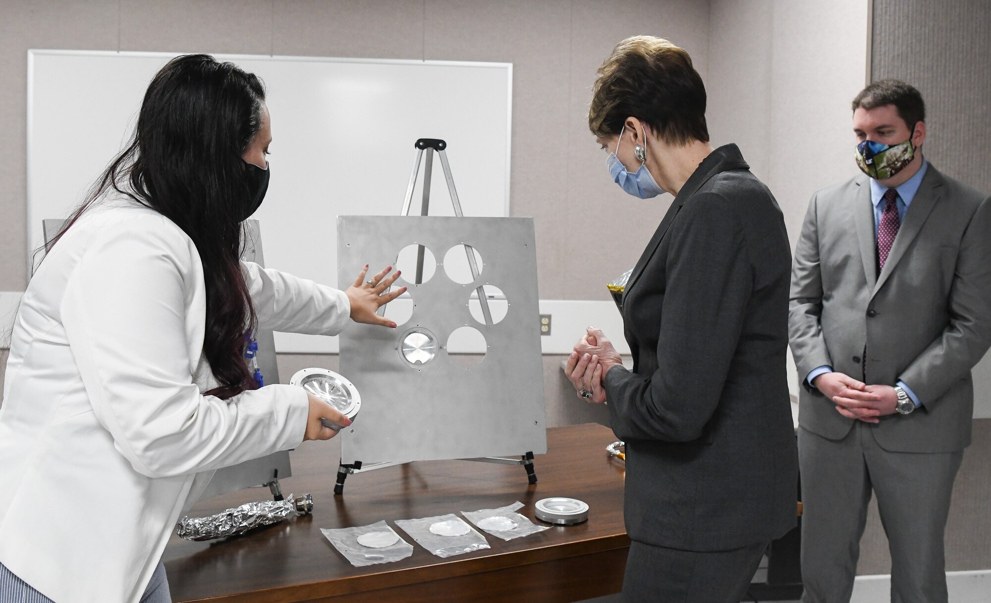 Kellye Burns, left, a space test engineer, shows Secretary of the Air Force Barbara Barrett some of the hardware and samples used during a materials test in the Space Threat Assessment Testbed at Arnold Air Force Base, Tenn., June 18, 2020. Also pictured is John Claybrook, capability manager for Space Asset Resilience. (U.S. Air Force photos by Jill Pickett)