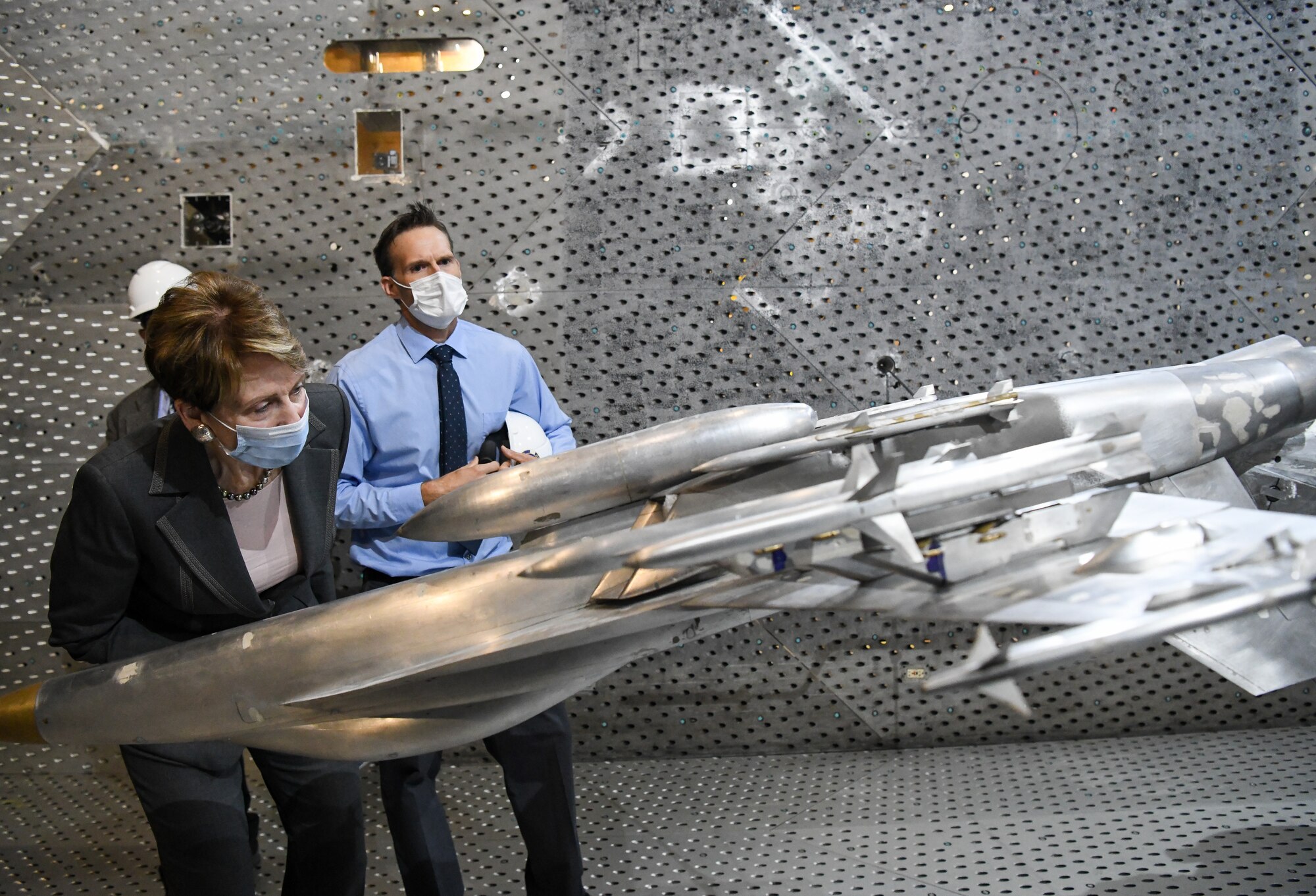 Secretary of the Air Force Barbara Barrett looks at a model of an F-18 Super Hornet in the Arnold Engineering Development Complex 16-foot Transonic Wind Tunnel during her visit, June 18, 2020, to Arnold Air Force Base, Tenn. Also pictured is Dr. Rich Roberts, flight commander for store separation. (U.S. Air Force photos by Jill Pickett)