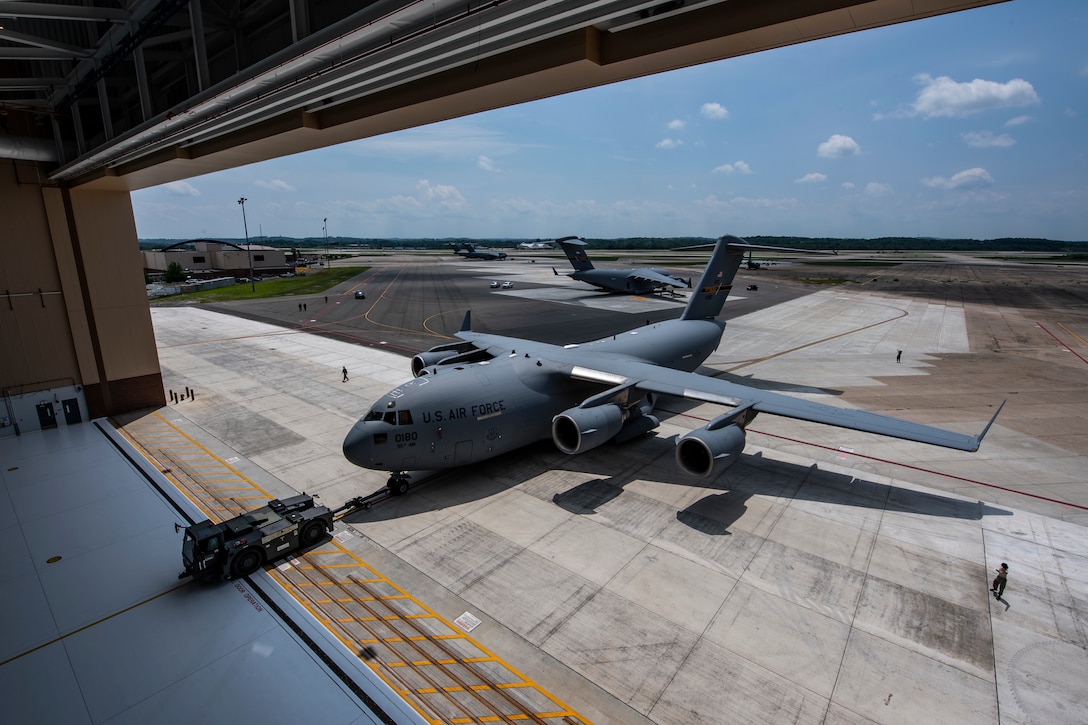 Airmen tow a C-17 Globemaster III into the new two-bay hangar