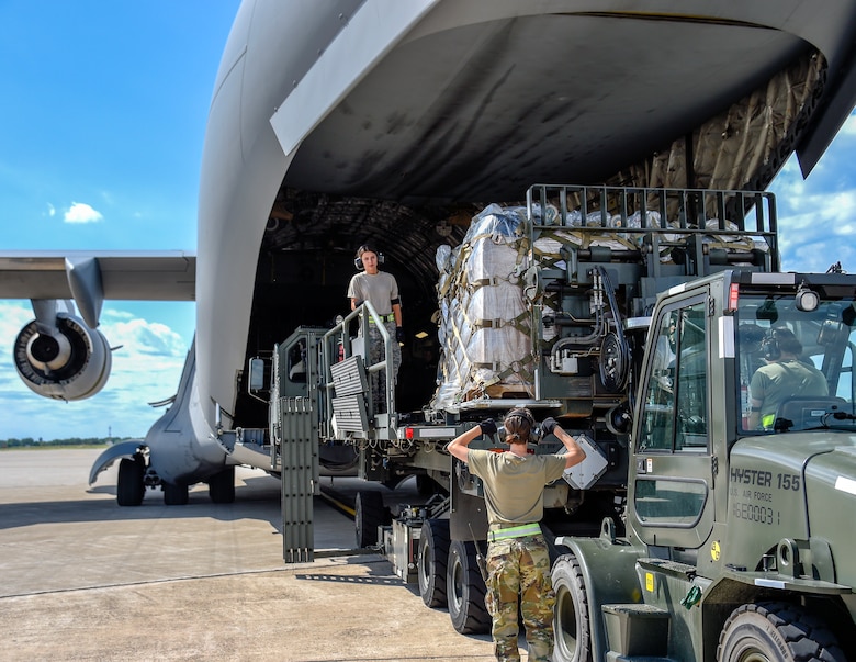 Air transportation specialists direct and load medical supplies onto a C-17 Globemaster III
