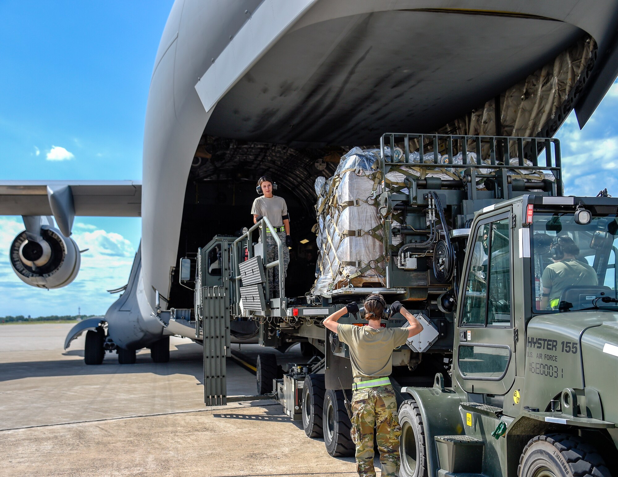 Tech. Sgt. Heather Boutin and Senior Airman Megan Lenling, 133rd Airlift Wing’s Air Transportation Function air transportation specialists, direct and load medical supplies onto a C-17 Globemaster III during a Denton Humanitarian Assistance Program mission, June 13, 2020, at the Minneapolis-St. Paul Joint Air Reserve Station, Minn. The cargo was destined for people with disabilities in Danli, Honduras. (U.S. Air Force photo by Tech. Sgt. Bristol L. Evasco)