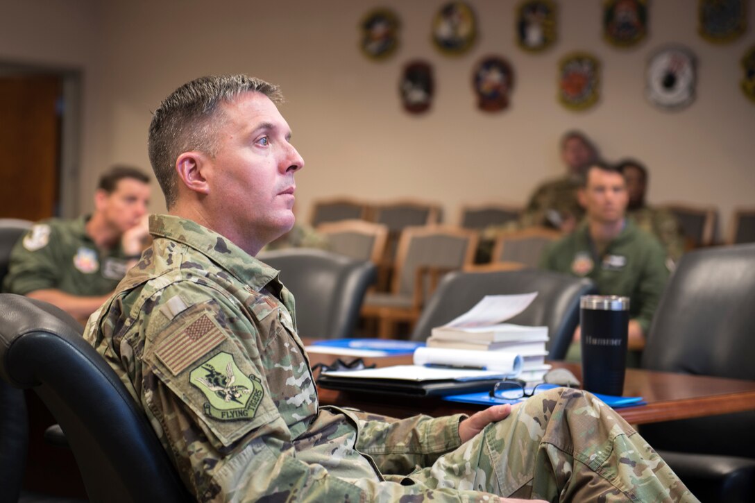 A photo of a Colonel listening to a briefing.