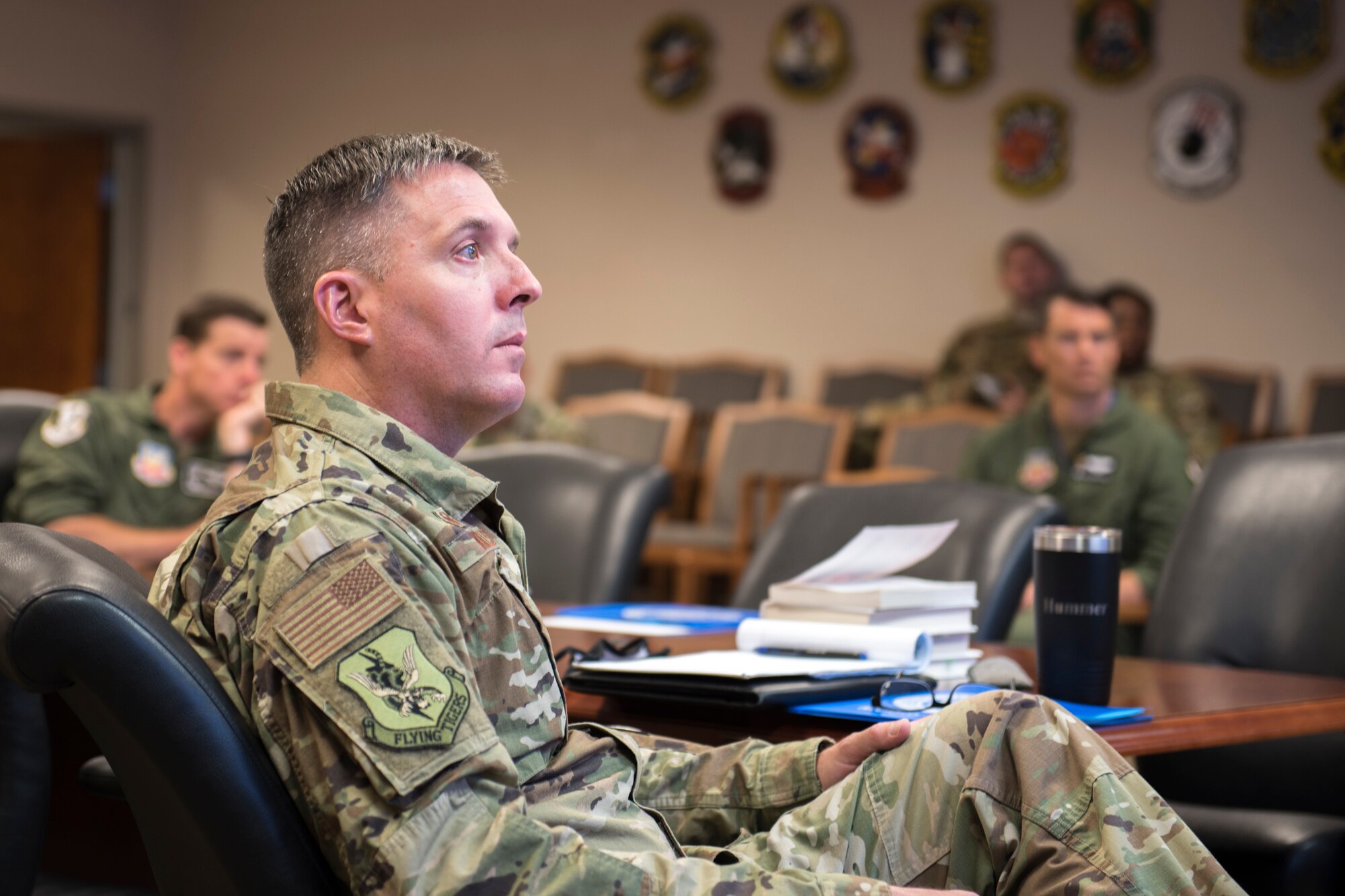 A photo of a Colonel listening to a briefing.