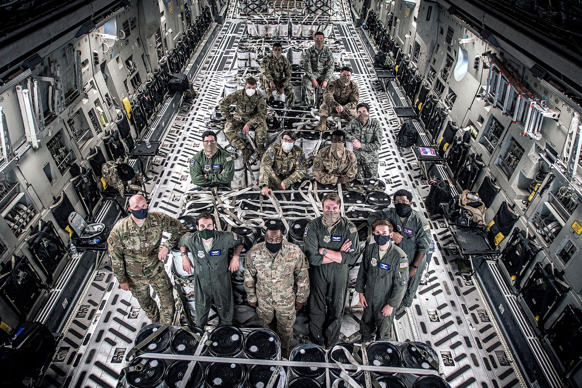 Group of Airmen pose for a group photo on a C-17.