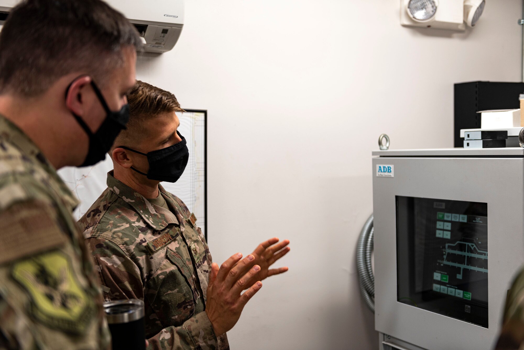 Photo of Airman explain functionality of an airfield control panel.