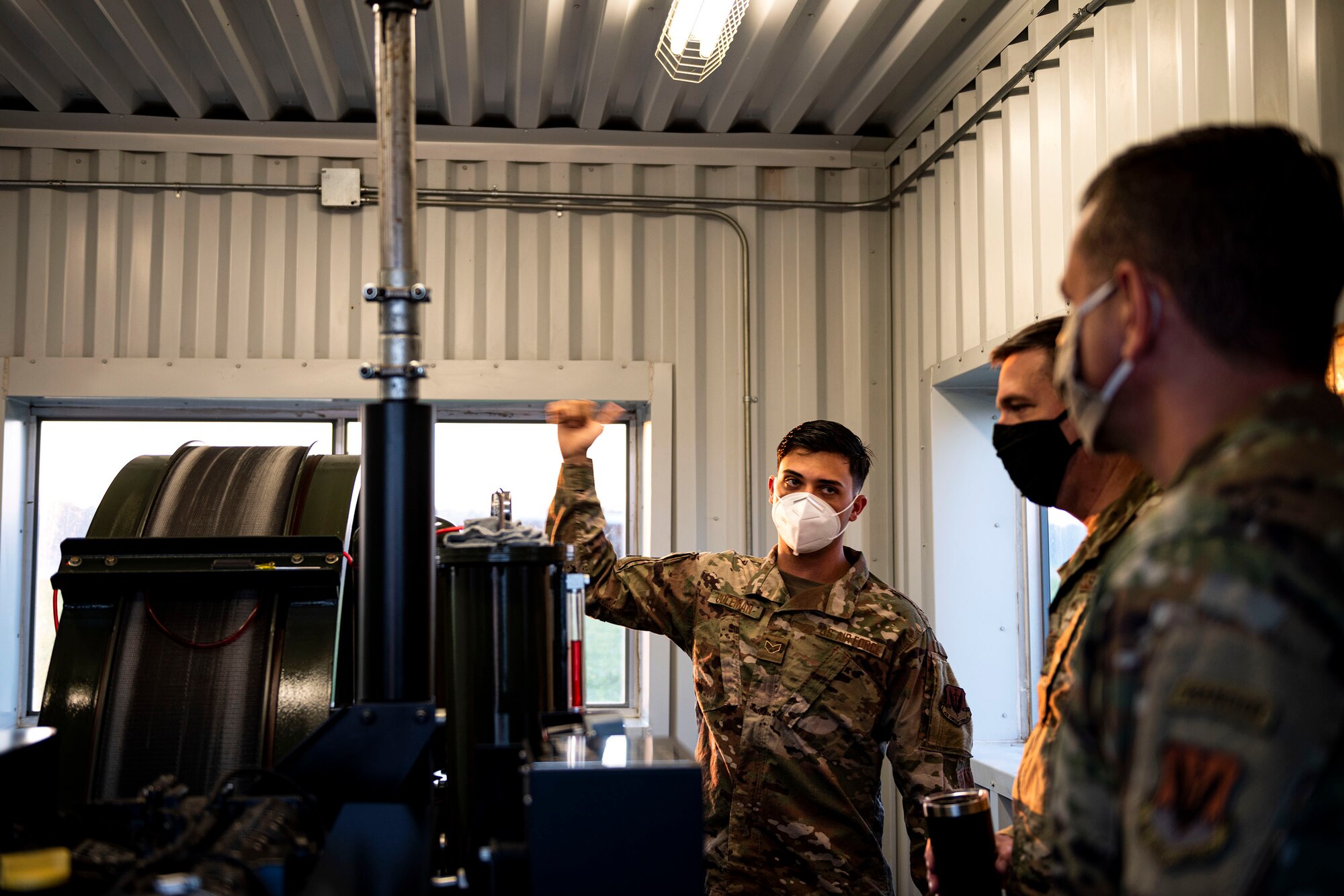 Photo of Airman explaining the functionality of a barrier arresting kit.