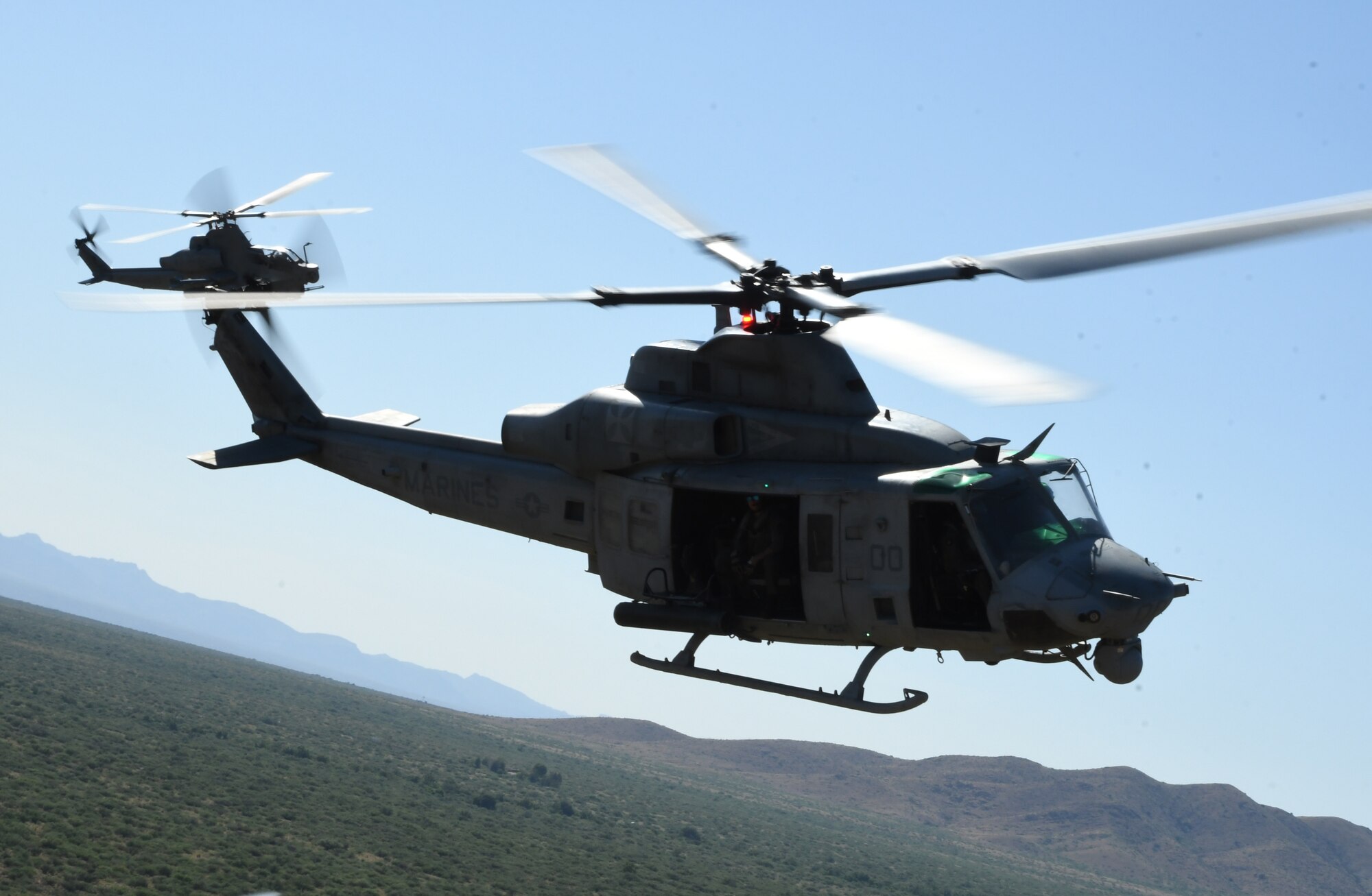 A picture of two helicopters flying.