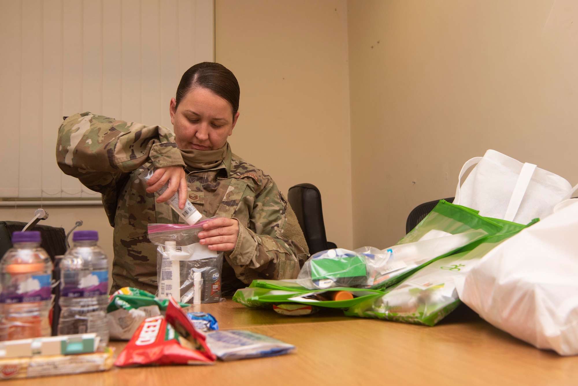 Master Sgt. Aisling Loftus, 100th Force Support Squadron postal superintendent, assembles a care package of hygiene items at RAF Mildenhall, England, June 15, 2020. Loftus spearheaded an initiative led by the Top-3 committee to collect hygiene items, snacks, and money for local healthcare workers. (U.S. Air Force photo by Airman 1st Class Joseph Barron)