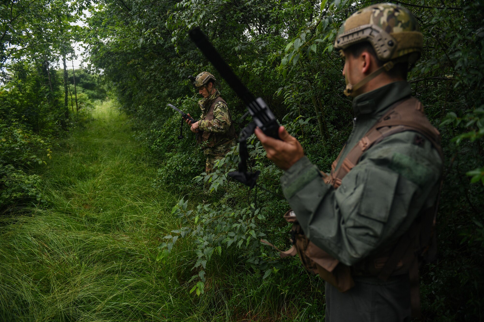 U.S. Air Force Capt. James Gregory, 510th Fighter Squadron pilot and Maj. Matthew Robins, 555th Fighter Squadron pilot, use their radios during an exercise at Rivolto Air Base, Italy, June 10, 2020. The pilots were undergoing a simulated Survival, Evasion, Resistance, Escape (SERE) training in which they had to survive and make contact with the proper sources after landing in enemy territory. (U.S. Air Force photo by Airman 1st Class Thomas S. Keisler IV)