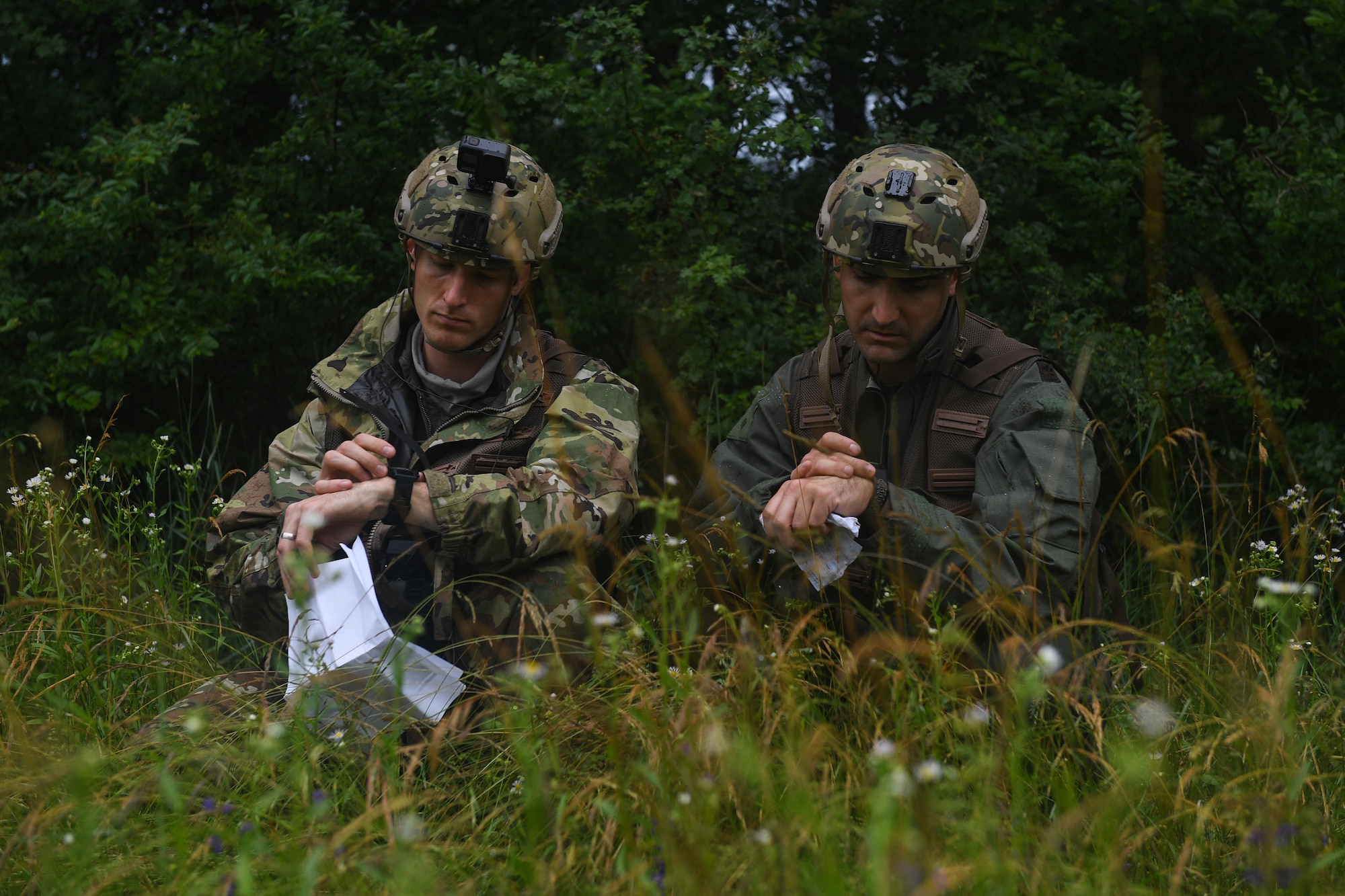 U.S. Air Force Capt. James Gregory, 510th Fighter Squadron pilot and Maj. Matthew Robins, 555th Fighter Squadron pilot, use their radios during an exercise at Rivolto Air Base, Italy, June 10, 2020. The pilots were undergoing a simulated Survival, Evasion, Resistance, Escape (SERE) training in which they had to survive and make contact with the proper sources after landing in enemy territory. (U.S. Air Force photo by Airman 1st Class Thomas S. Keisler IV)