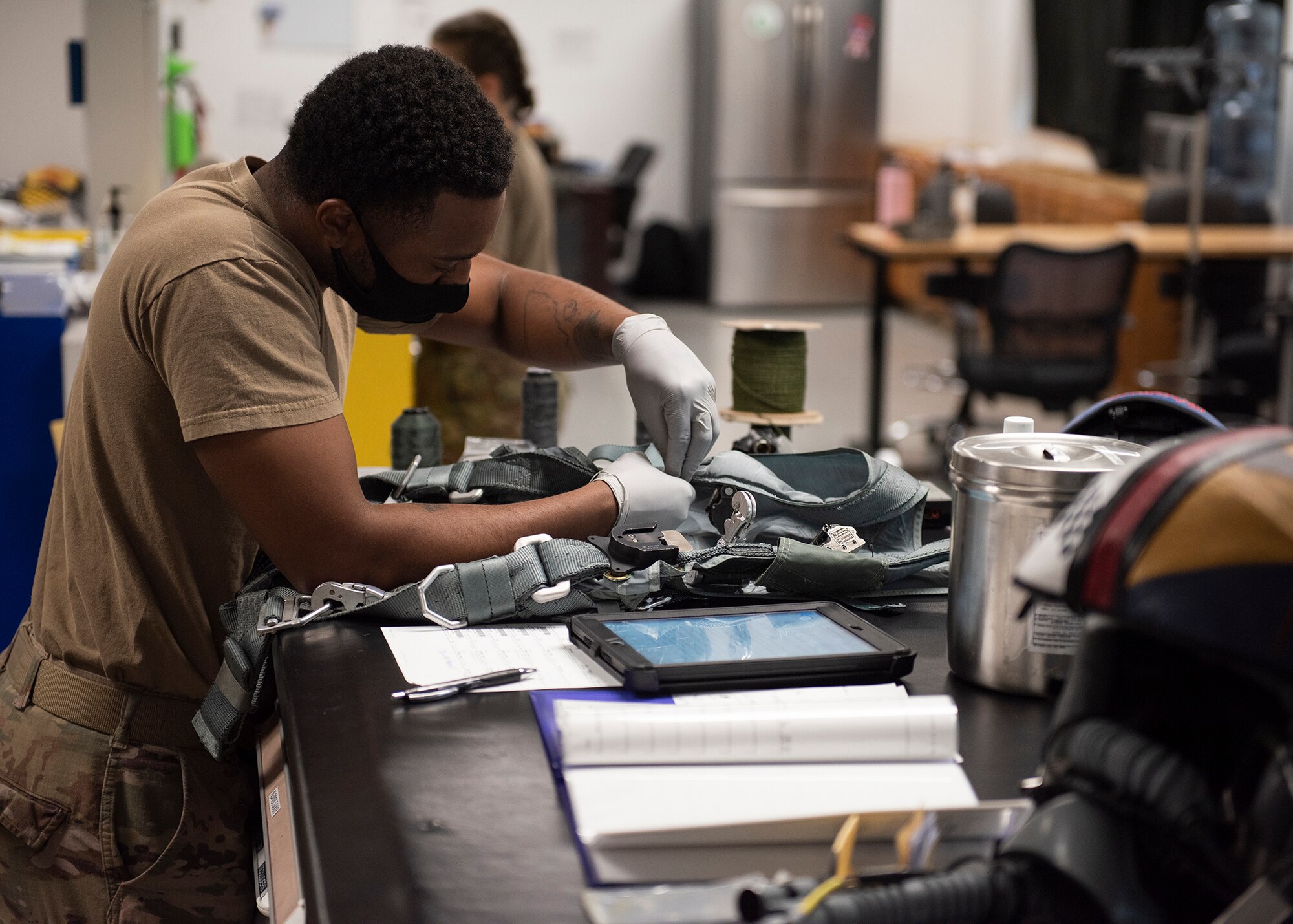 Senior Airman Melvin Wells, 57th Weapons Support Squadron aircrew flight equipment technician, inspects a harness at Nellis Air Force Base, Nev., June 3, 2020. AFE technicians assigned to the WPSS repair flight and aircrew equipment for 18 different aircraft used by the school. (U.S. Air Force photo by Airman 1st Class Bryan Guthrie)