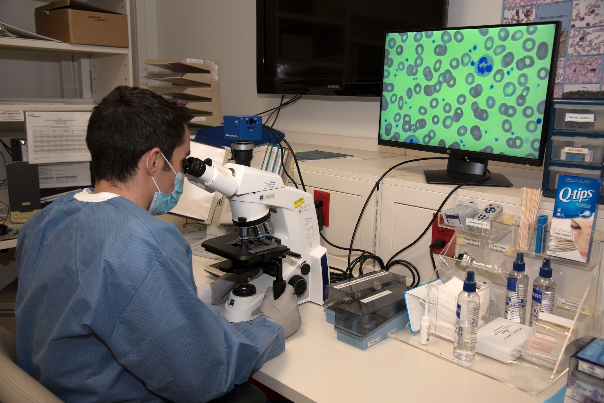 U.S. Air Force Staff Sgt. Anthony Presti, a medical laboratory technician at the 21st Medical Group clinical laboratory, views a sample under a microscope. The lab at Peterson Air Force Base, Colorado, generates more than 4,700 lab results on average each month. (U.S. Air Force photo by Kristen Allen)