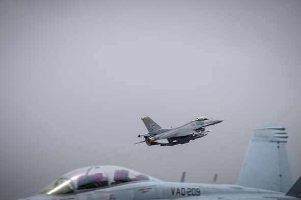 A U.S. Air Force F-16 Fighting Falcon flies over a U.S. Navy Boeing EA-18G during a PAC Weasel exercise at Misawa Air Base, Japan, June 19, 2020. This exercise allows 35th Operations Group intelligence Airmen, and the U.S. Navy Electronic Attack Squadron 209 (VAQ-209) to integrate at a classified level. This coordination and sharing of training and operational tactics techniques and procedures (TTPs) is extremely helpful. (U.S. Air Force photo by Airman 1st Class China M. Shock)