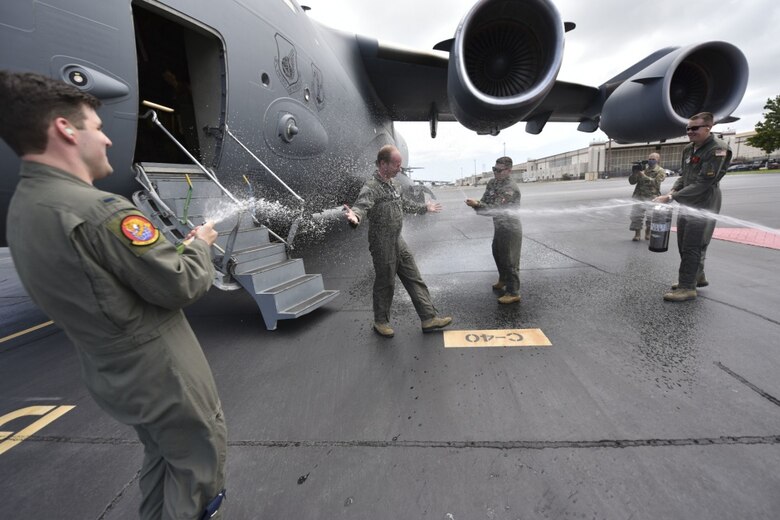 U.S. Air Force Airmen from the 15th Wing spray U.S. Air Force Col. W. Halsey Burks, 15th Wing commander, with water to celebrate his fini flight at Joint Base Pearl Harbor-Hickam, Hawaii, June 9, 2020. The fini flight is a tradition among pilots which celebrates their final flight as a member of the unit. Tail number 5148 is the same aircraft Burks flew from the Boeing factory to Hickam Field in 2006. (U.S. Air Force photo by Tech. Sgt. Anthony Nelson Jr.)