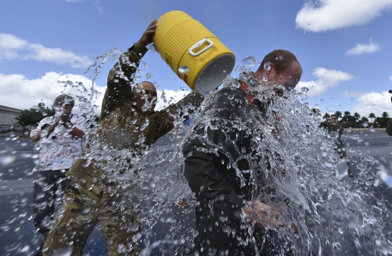 U.S. Air Force Airmen from the 15th Wing spray U.S. Air Force Col. W. Halsey Burks, 15th Wing commander, with water to celebrate his fini flight at Joint Base Pearl Harbor-Hickam, Hawaii, June 9, 2020. The fini flight is a tradition among pilots which celebrates their final flight as a member of the unit. Tail number 5148 is the same aircraft Burks flew from the Boeing factory to Hickam Field in 2006. (U.S. Air Force photo by Tech. Sgt. Anthony Nelson Jr.)