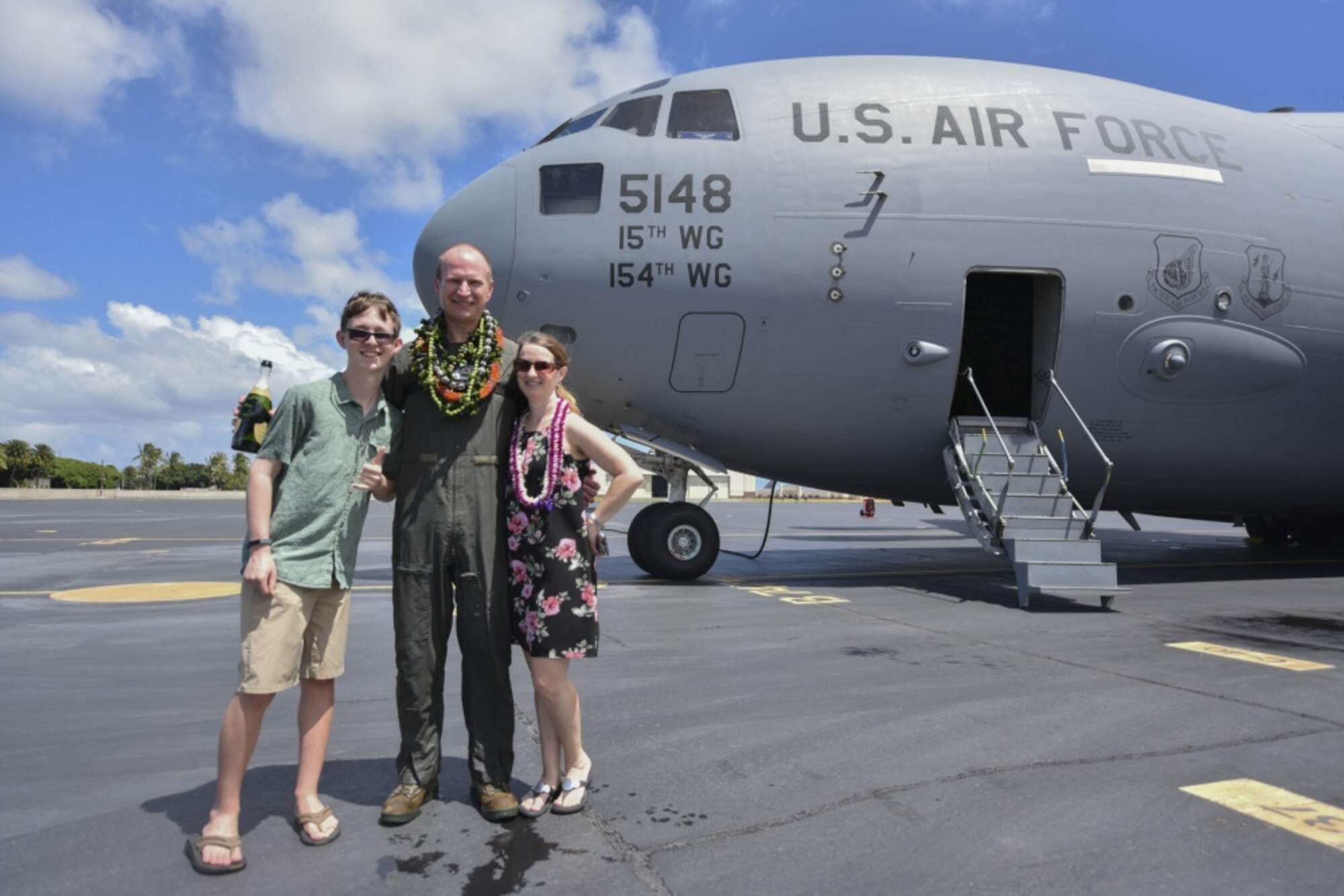 U.S. Air Force Col. W. Halsey Burks, 15th Wing commander, and his wife Susan and son Ethan pose for a photo after his fini flight at Joint Base Pearl Harbor-Hickam, Hawaii, June 9, 2020. The fini flight is a tradition among pilots which celebrate their final flight as a member of the unit. Tail number 5148 is the same aircraft Burks flew from the Boeing factory to Hickam Field in 2006. (U.S. Air Force photo by Tech. Sgt. Anthony Nelson Jr.)