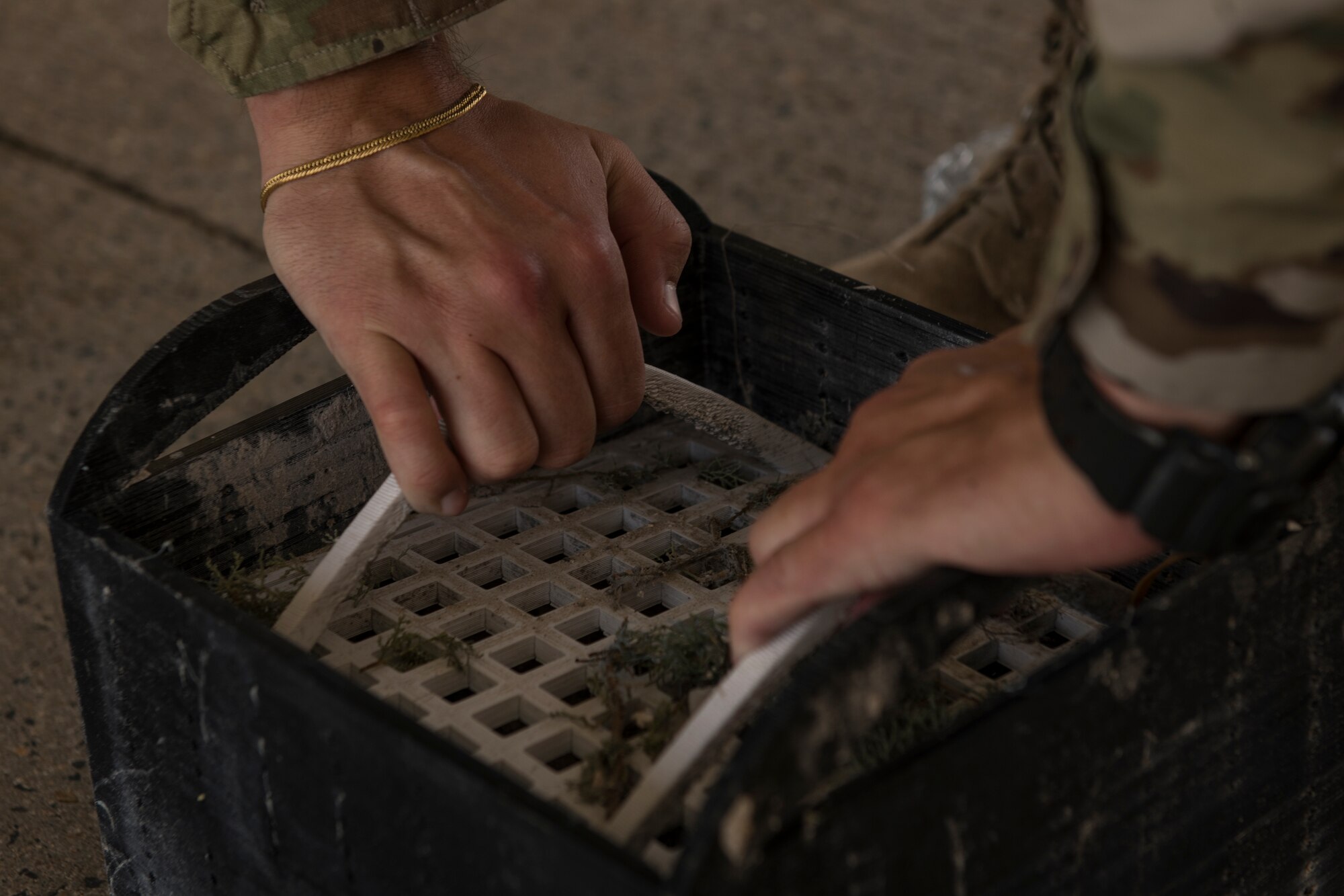 U.S. Air Force Senior Airman Ryan Disher, a vehicle operator assigned to the 379th Expeditionary Logistics Readiness Squadron, inspects a prototype drainage pan from a vehicle wash rack at Al Udeid Air Base, Qatar, June 13, 2020.
