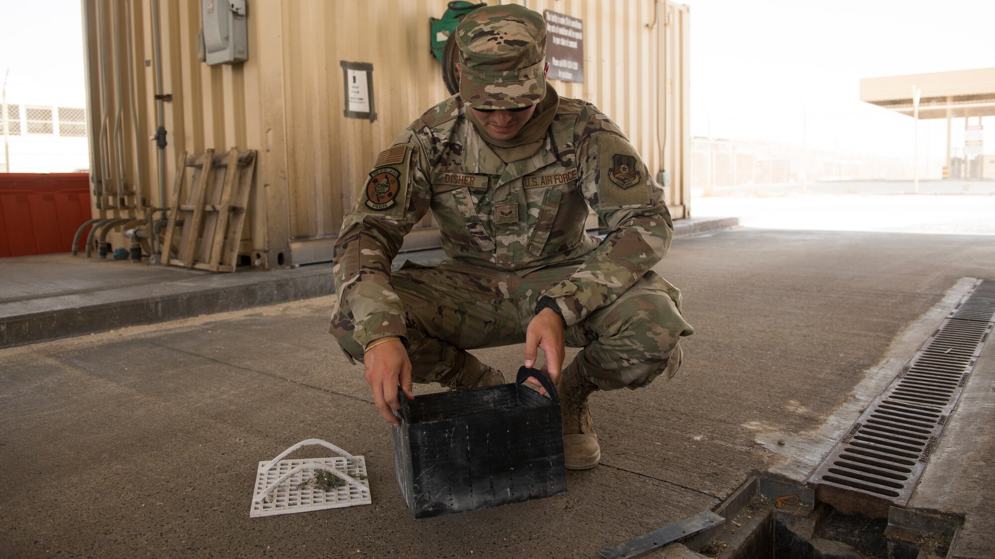 U.S. Air Force Senior Airman Ryan Disher, a vehicle operator assigned to the 379th Expeditionary Logistics Readiness Squadron, inspects a prototype drainage pan from a vehicle wash rack at Al Udeid Air Base, Qatar, June 13, 2020.