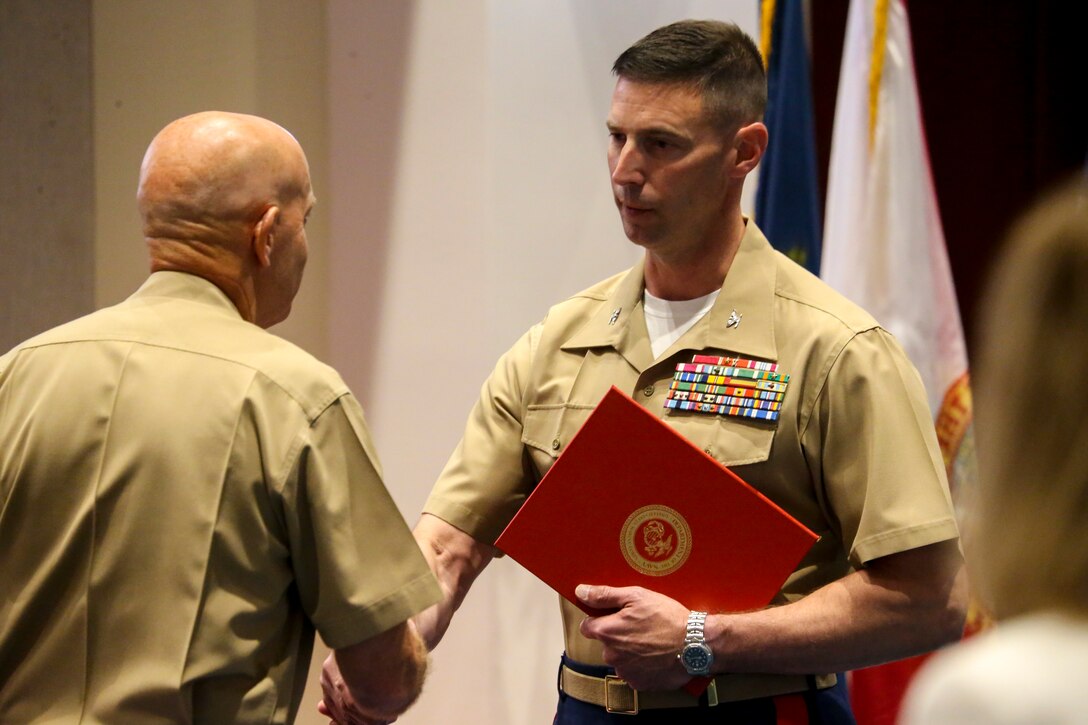 General David H. Berger, left, 38th Commandant of the Marine Corps, awards Col. Donald J. Tomich, right, outgoing commanding officer, for his meritorious service while serving at the Barracks, June 17, 2020. Colonel Donald J. Tomich relinquished his command of Marine Barracks Washington D.C. to Col. Teague A. Pastel. Pastel previously served as the Deputy Commandant for Information (DC I) where he served as the Director, Plans and Strategy Division.