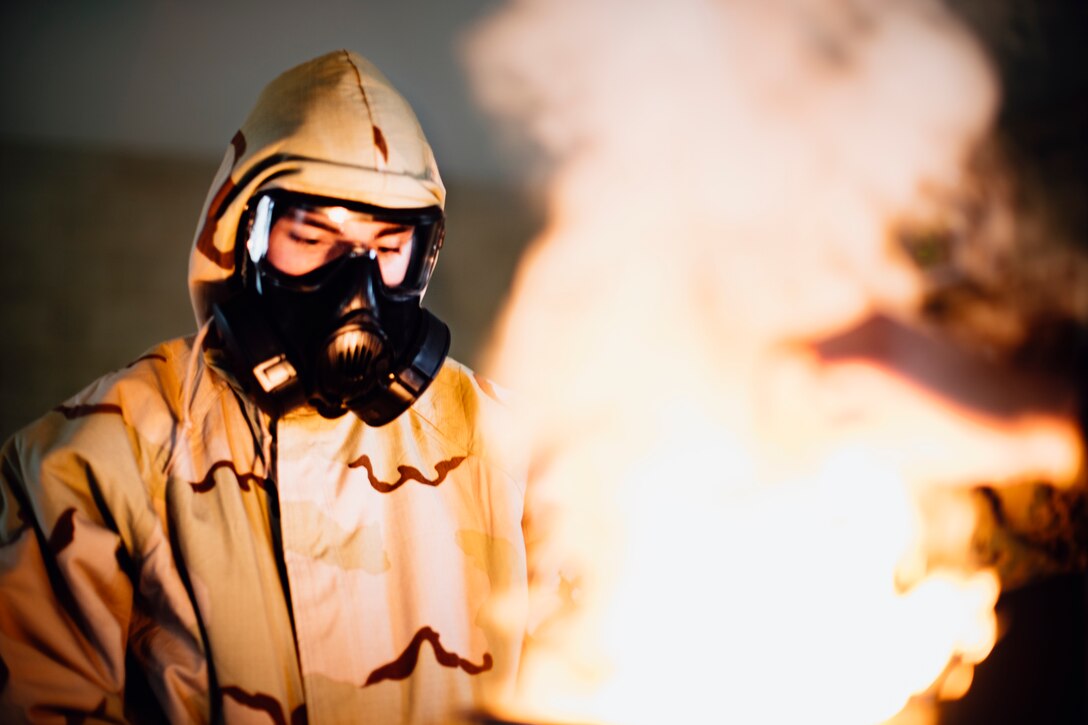 A U.S. Marine burns a non-lethal chlorobenzylidene malononitrile capsule during a gas chamber qualification at Marine Corps Base Camp Pendleton, Calif., June 19.