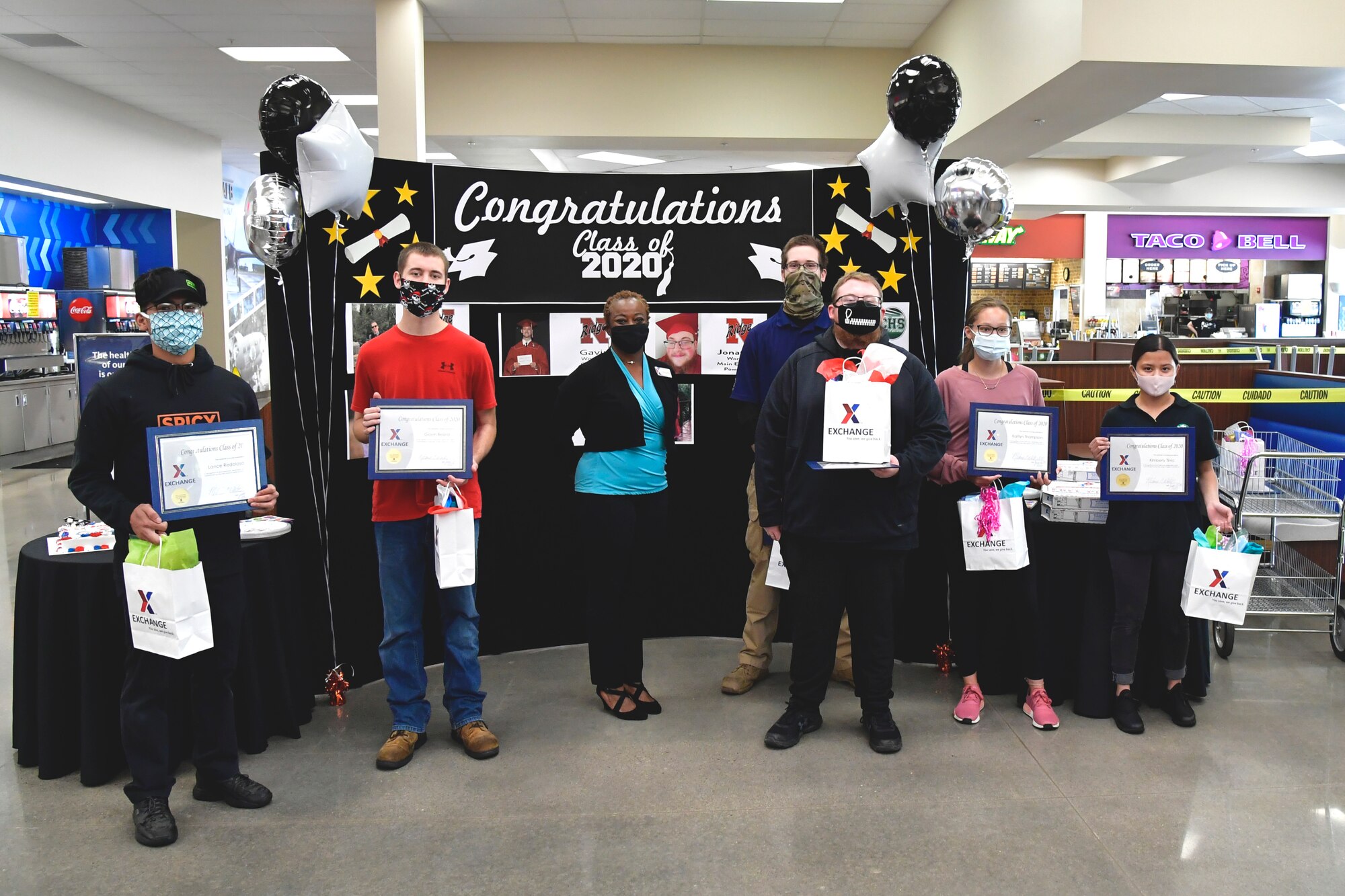 Melanie White, AAFES general manager, and seven student employees pose for a group photo with their recognition certificates.