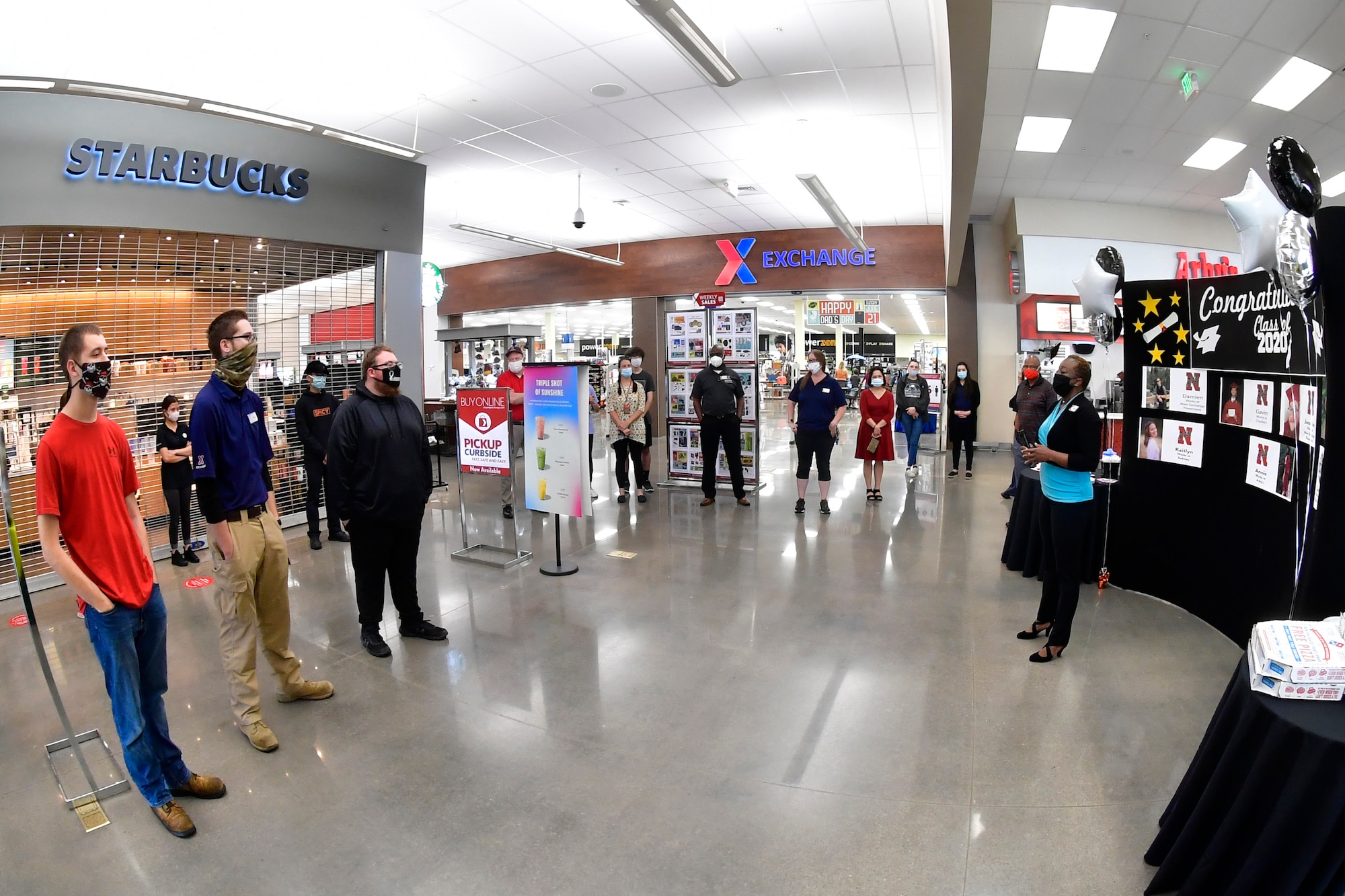 Melony White, AAFES general manager, addresses students, employees, families and friends inside the AAFES Main Exchange at the store entrance.