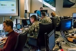 Members of the Colorado National Guard's Task Force Cyber help Colorado Secretary of State Wayne W. Williams monitor network traffic and advise Chief Information Officer Trevor Timmons Nov. 6, 2018. The Guard will once again be helping to protect the elections against cyberattack in June and November 2020.